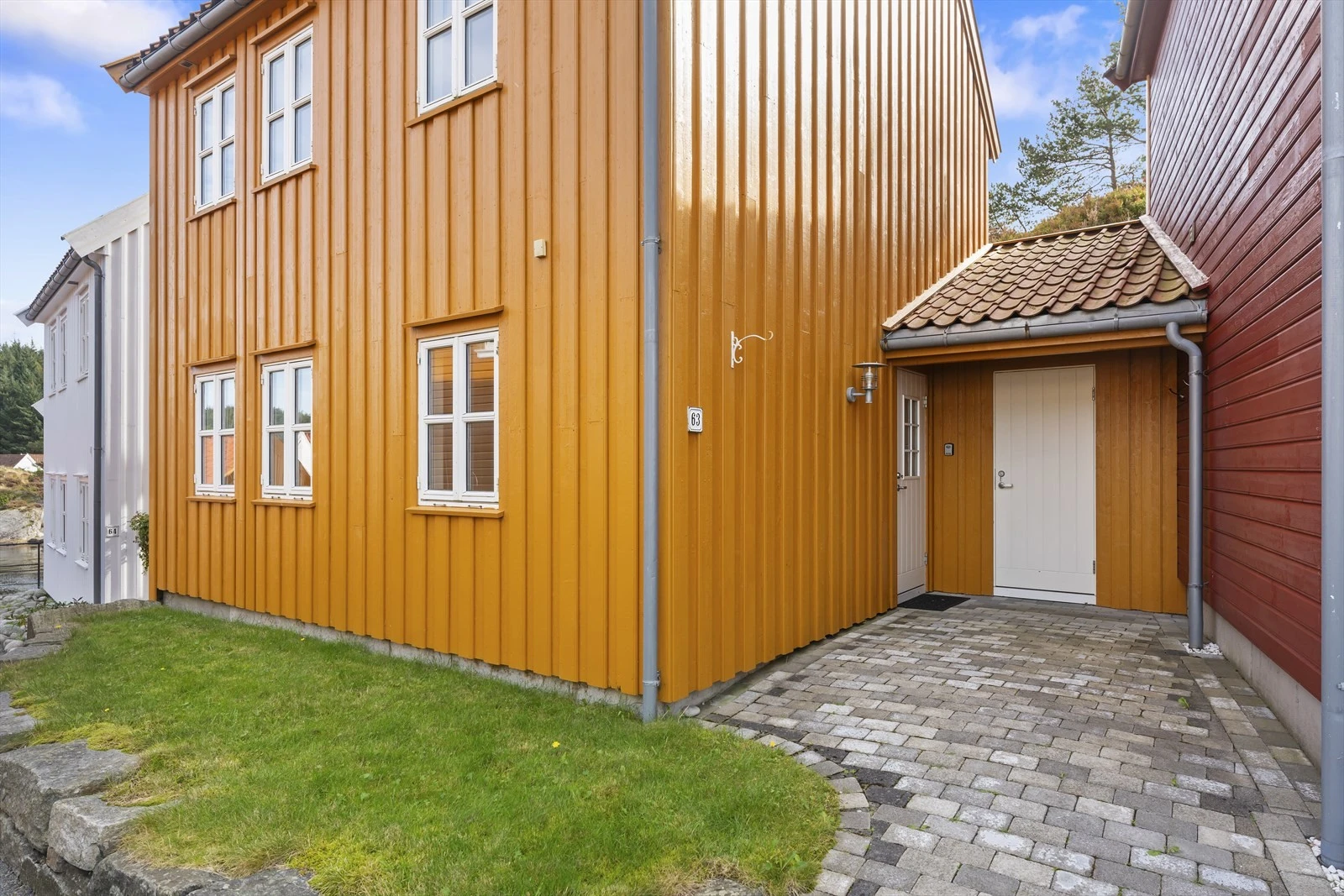 Ved inngangsparti har man en liten hageflekk, samt en utvendig bod for ekstra oppbevaring. Galleribilde