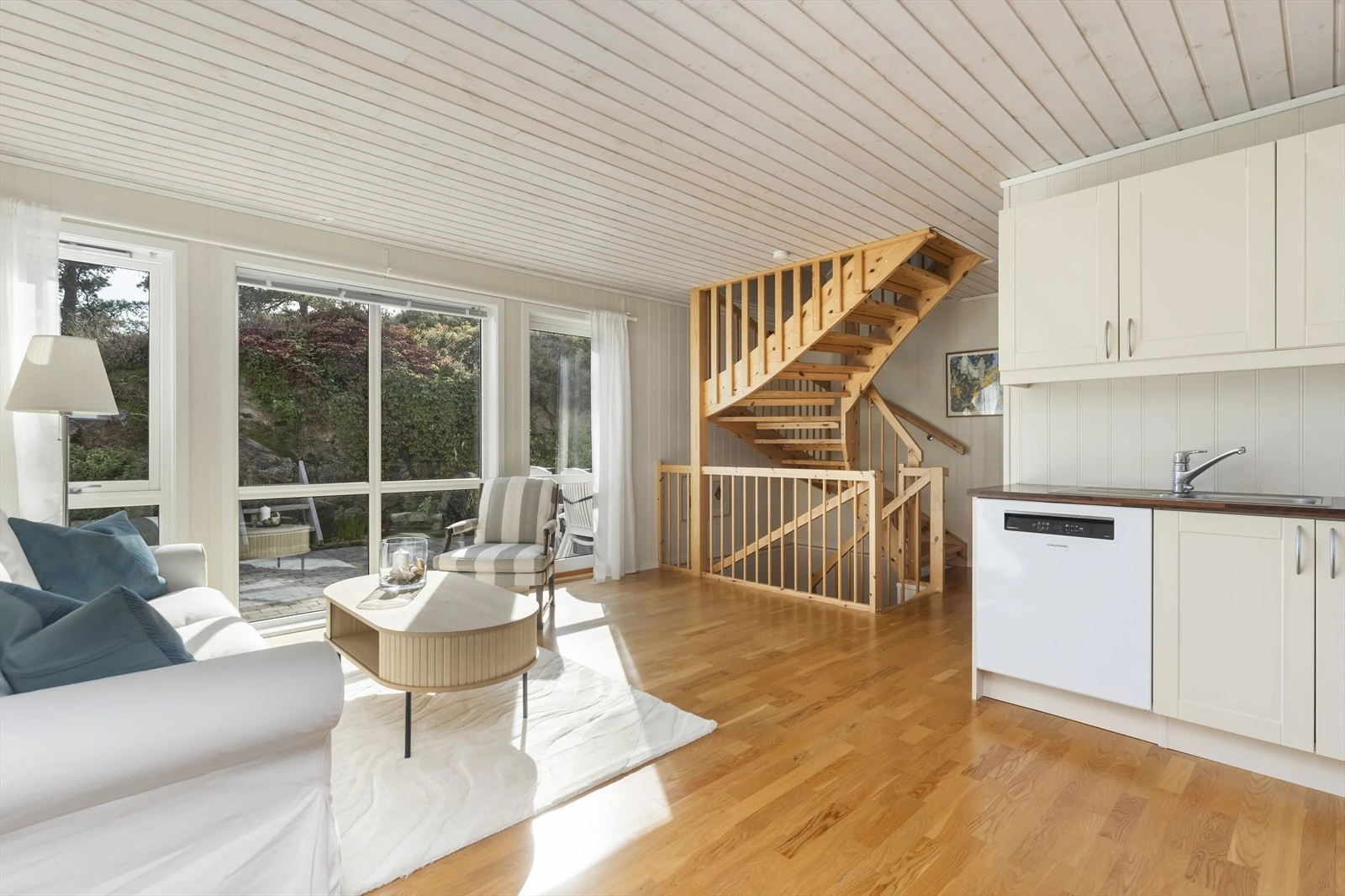 Her har man en lys og luftig stue med åpen kjøkkenløsning som gjør rommet til en sosial sone. Galleribilde