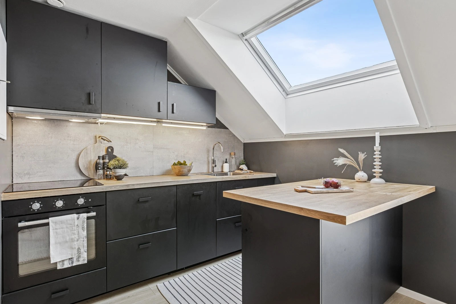 Kjøkkenet i dempet sort utførelse er fra 2023. Smarte løsninger som bl.a. skuff-i-skuff og alt av hvitevarer integrert - kombiskap (kjøl/frys), oppvaskmaskin, stekeovn og koketopp. Galleribilde