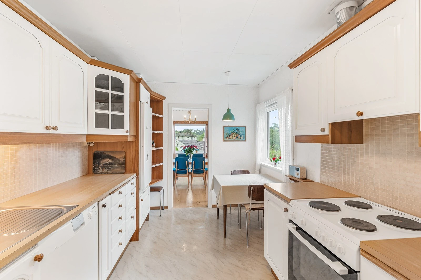 Kjøkkenet har profilerte, malte fronter og benkeplate i laminat med nedsenket vask og ettgreps blandebatteri Galleribilde