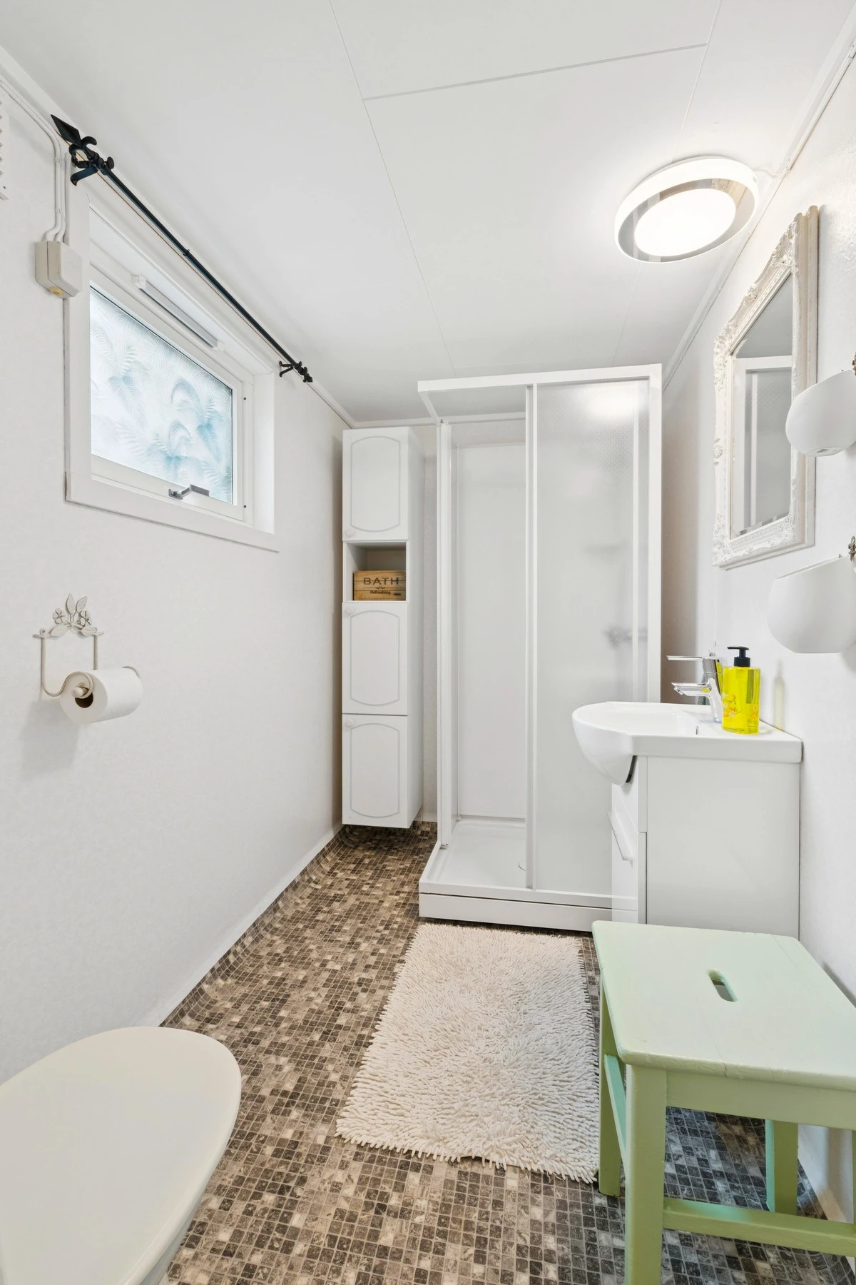 Praktisk og funksjonelt baderom med våtromstapet, himlingsplater og slitesterkt vinylbelegg Galleribilde