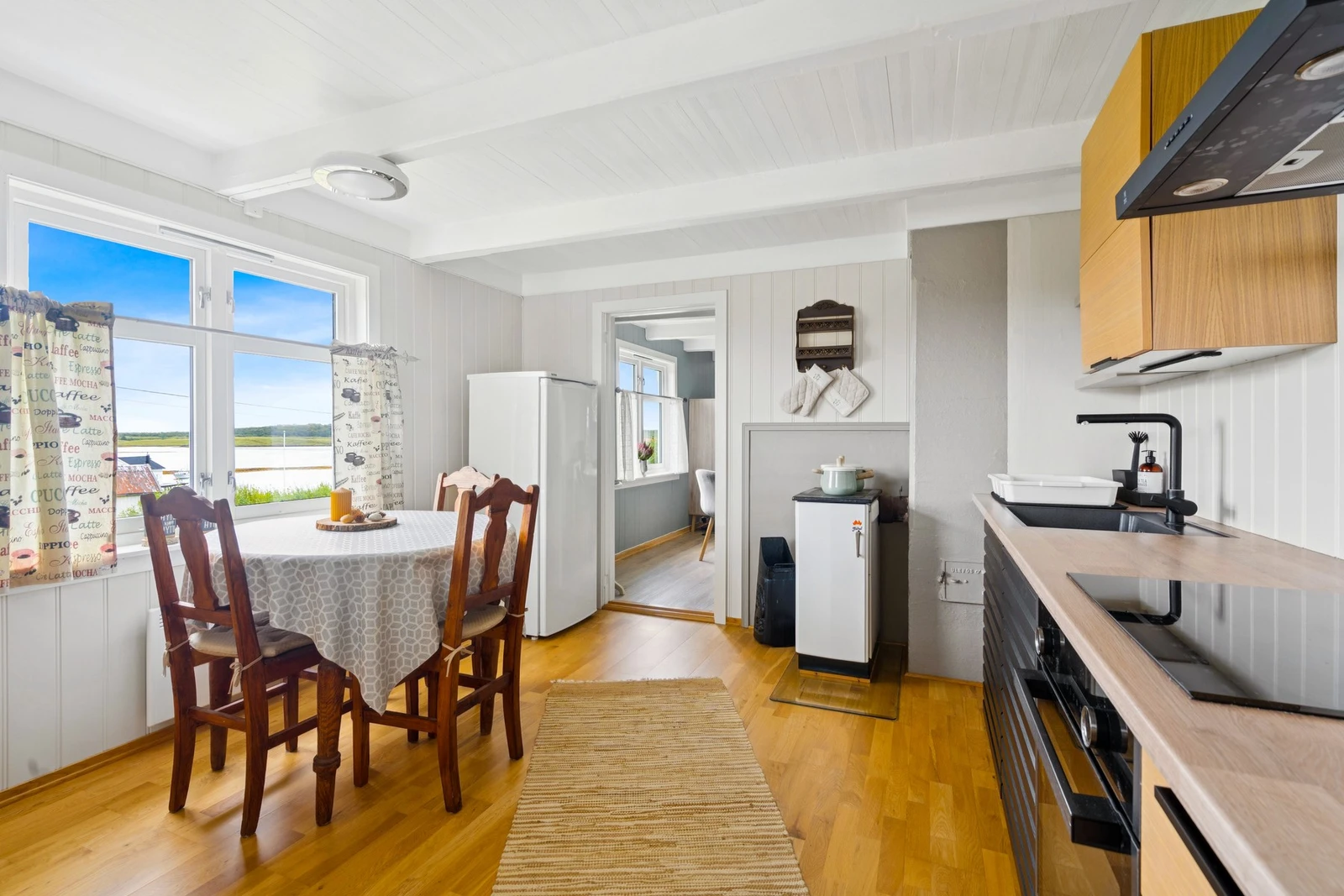 Kvalitetskjøkken med integrerte hvitevarer - koketopp med komfyrvakt, stekeovn og ventilator med kullfilter gir trygg og effektiv matlaging Galleribilde