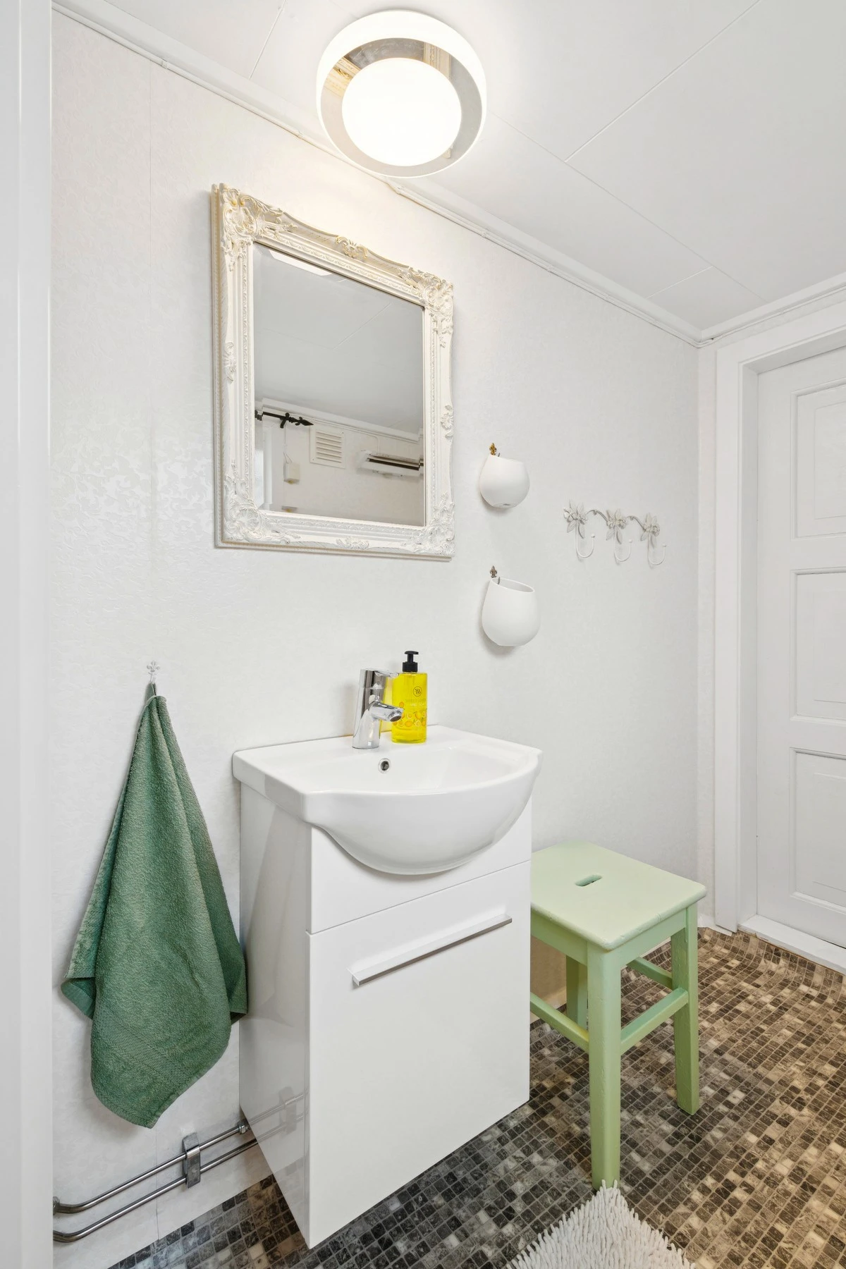 Badet er utstyrt med servant, toalett og dusjkabinett Galleribilde