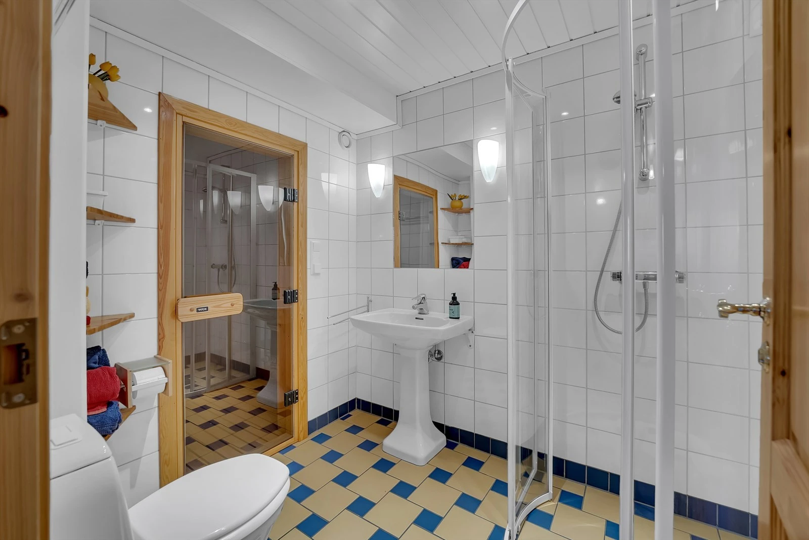 Bad i kjeller med dusj, servant, wc og inngang til badstue. Galleribilde