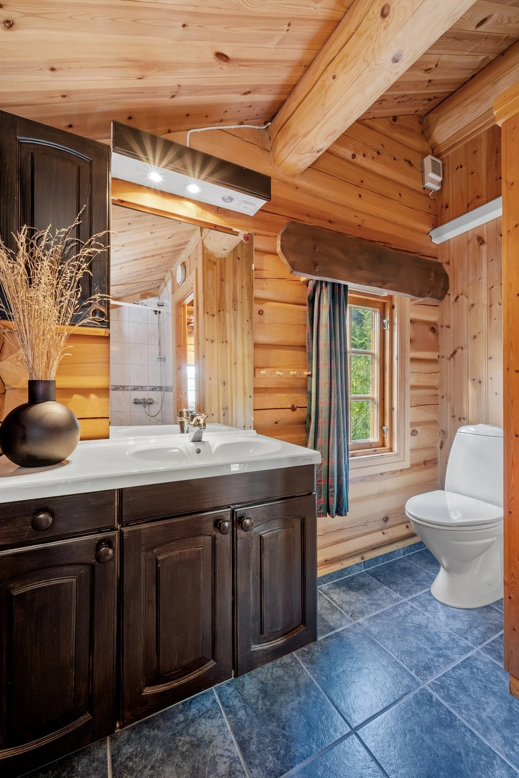 Det vinklete badet på 4 kvm utnytter arealet maksimalt, og kombinerer flott innredning med god takhøyde - for en både luftig og innbydende atmosfære. Galleribilde