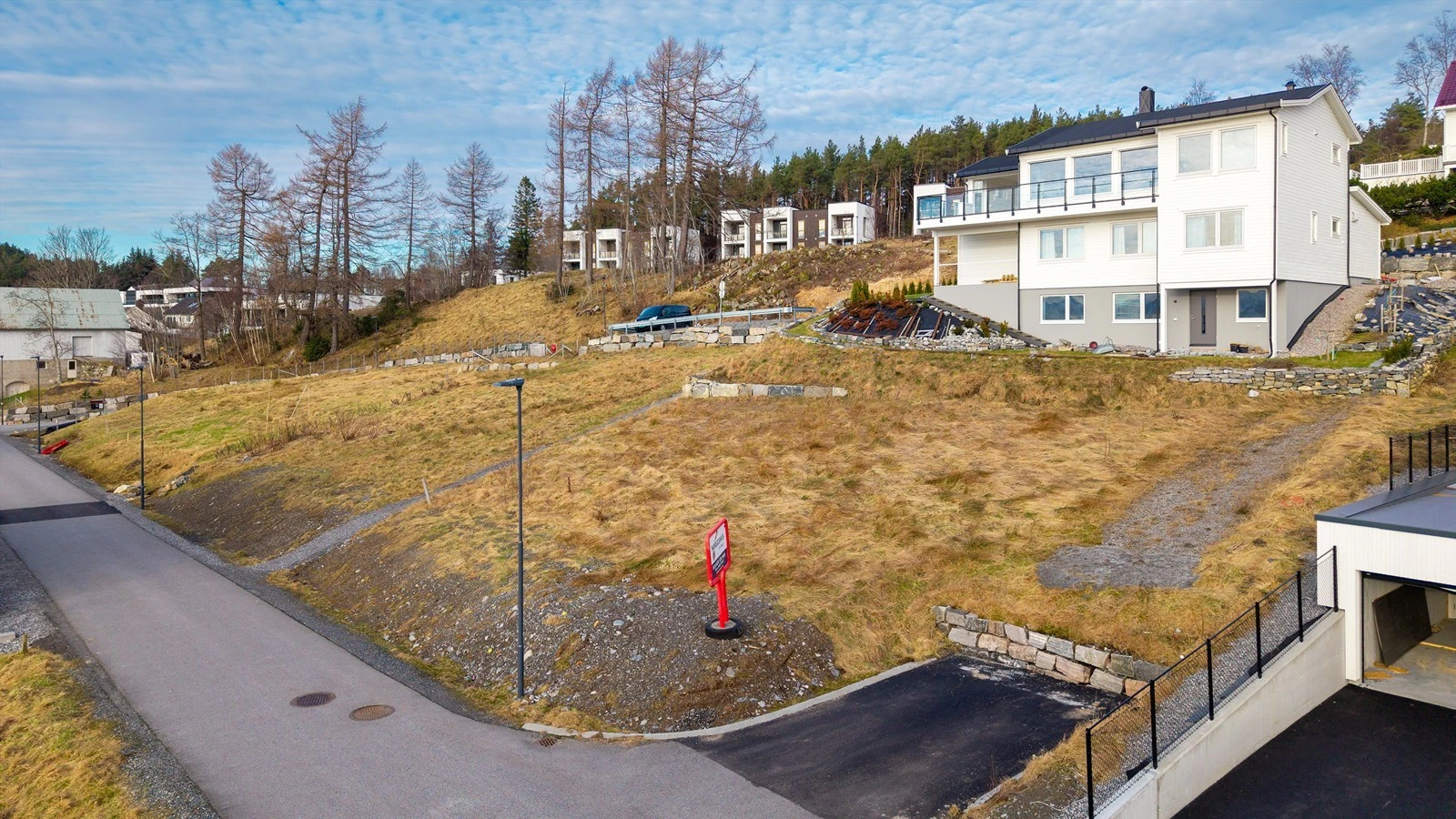 Tomten er beliggende i sydvendt skrånende terreng og grenser mot kommunal vei mot sør Galleribilde