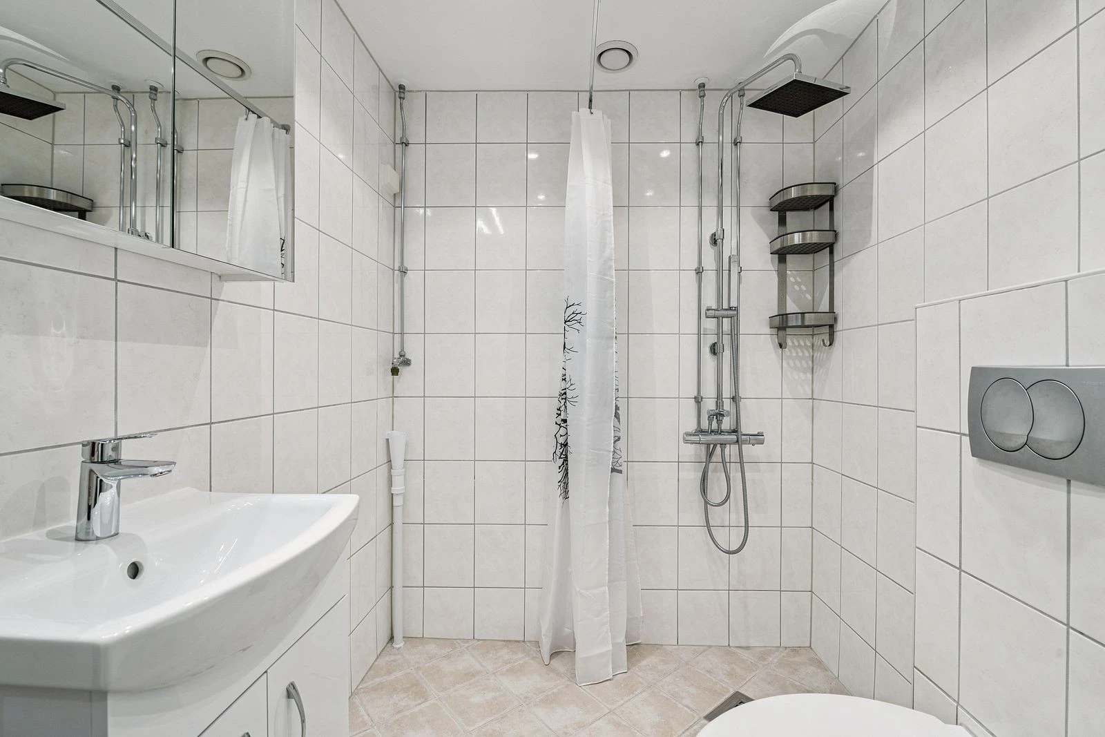 Et moderne baderom med god plass, flislagte overflater og tidløs design.