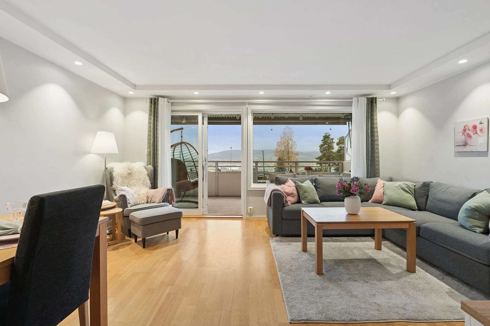 En lys og innbydende stue med balkong som forlenger oppholdsrommet.