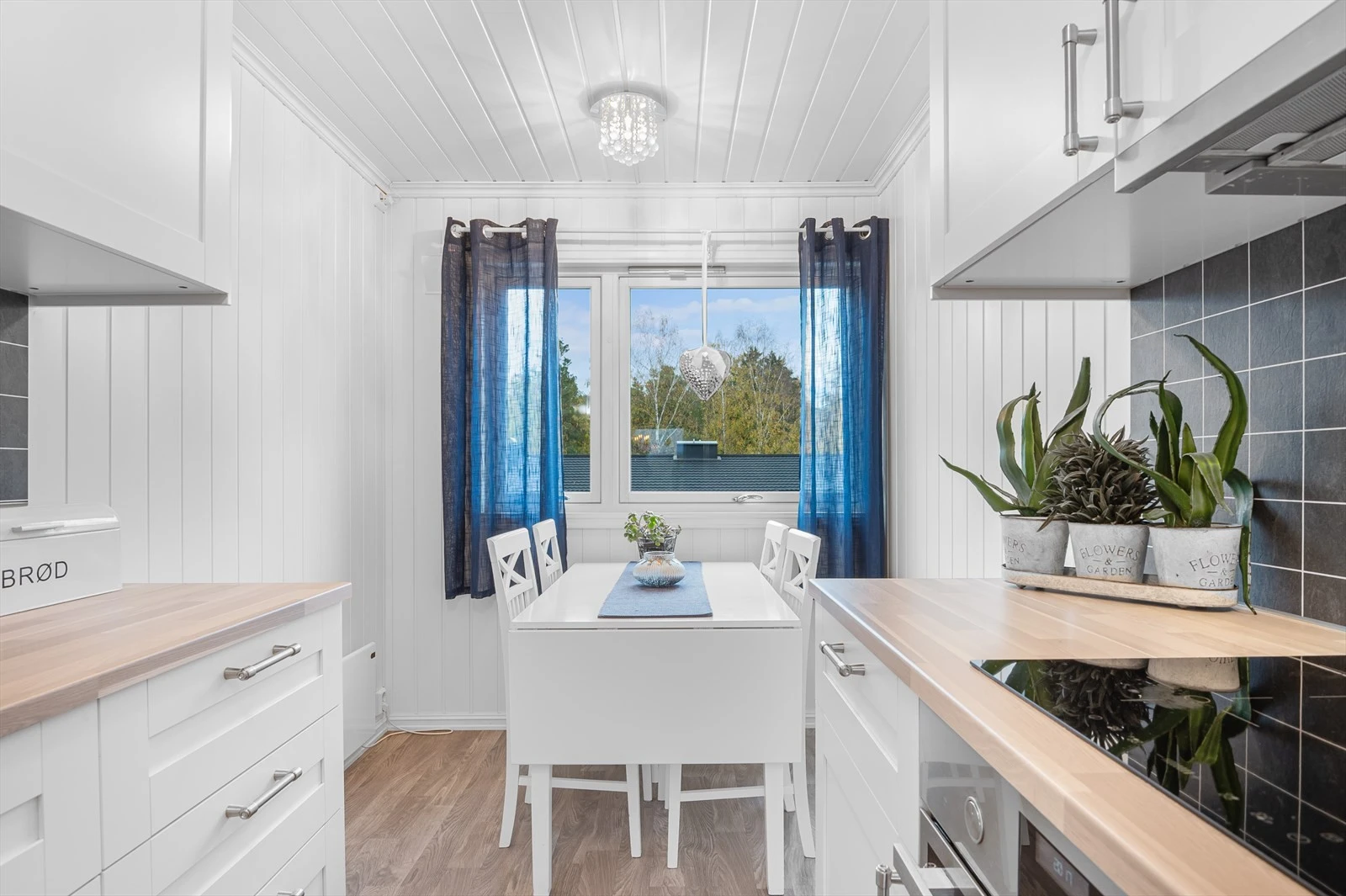 Det er plass til frokostbord ved vindu med hyggelig utsyn mot nabolaget. Galleribilde