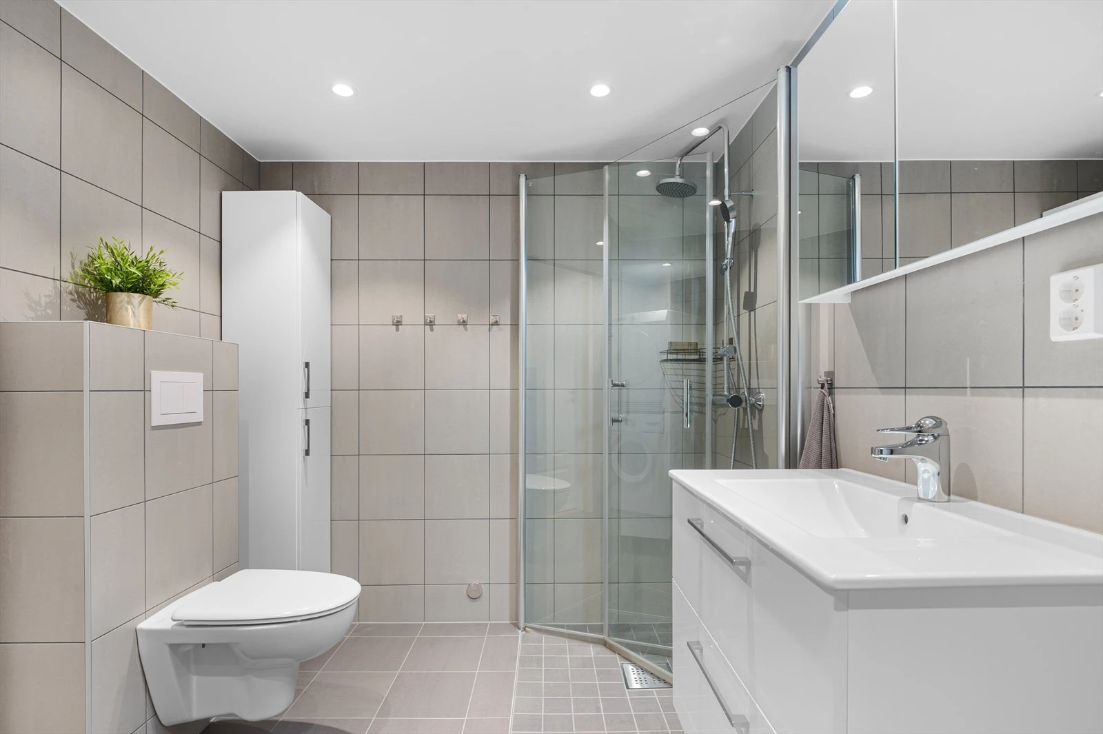 Badet som stod ferdig i 2023 har god størrelse og fremstår tidløst med flislagte overflater, gulvvarme, downlights og lys innredning. Galleribilde