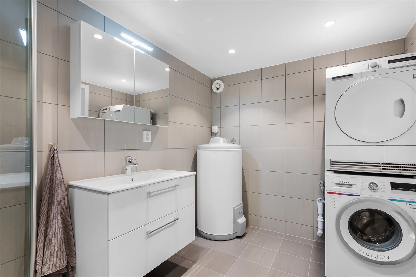 Innredningen består av blant annet bredt servantskap, speilskap med lys, dusjnisje med glassdører og røropplegg for vaskemaskin og tørketrommel. Galleribilde