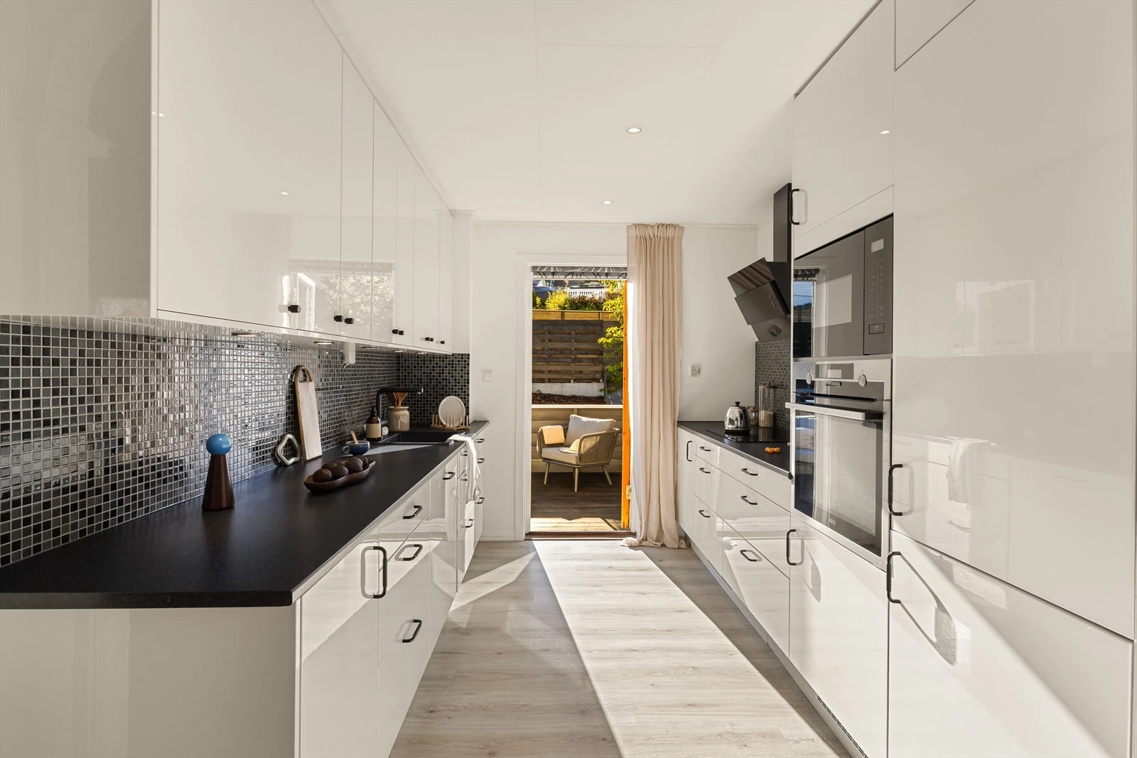 Kjøkkenet er levert av Epoq i 2022 med slette, hvite fronter og alle hvitevarer integrert. Galleribilde