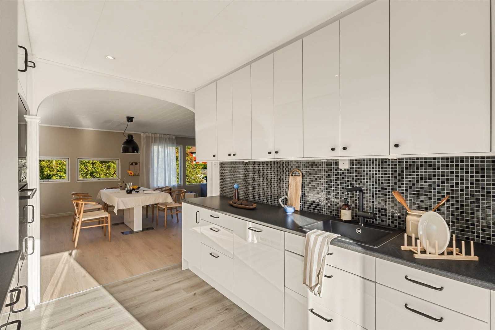 Matlagingen blir sosial med åpen løsning - samtidig delvis skjermet fra sofagruppen i stuen. Galleribilde