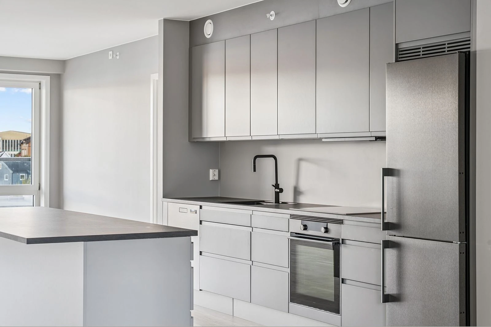 Stilrent kjøkken fra HTH med slette fronter, god arbeidsflate og kjøkkenøy