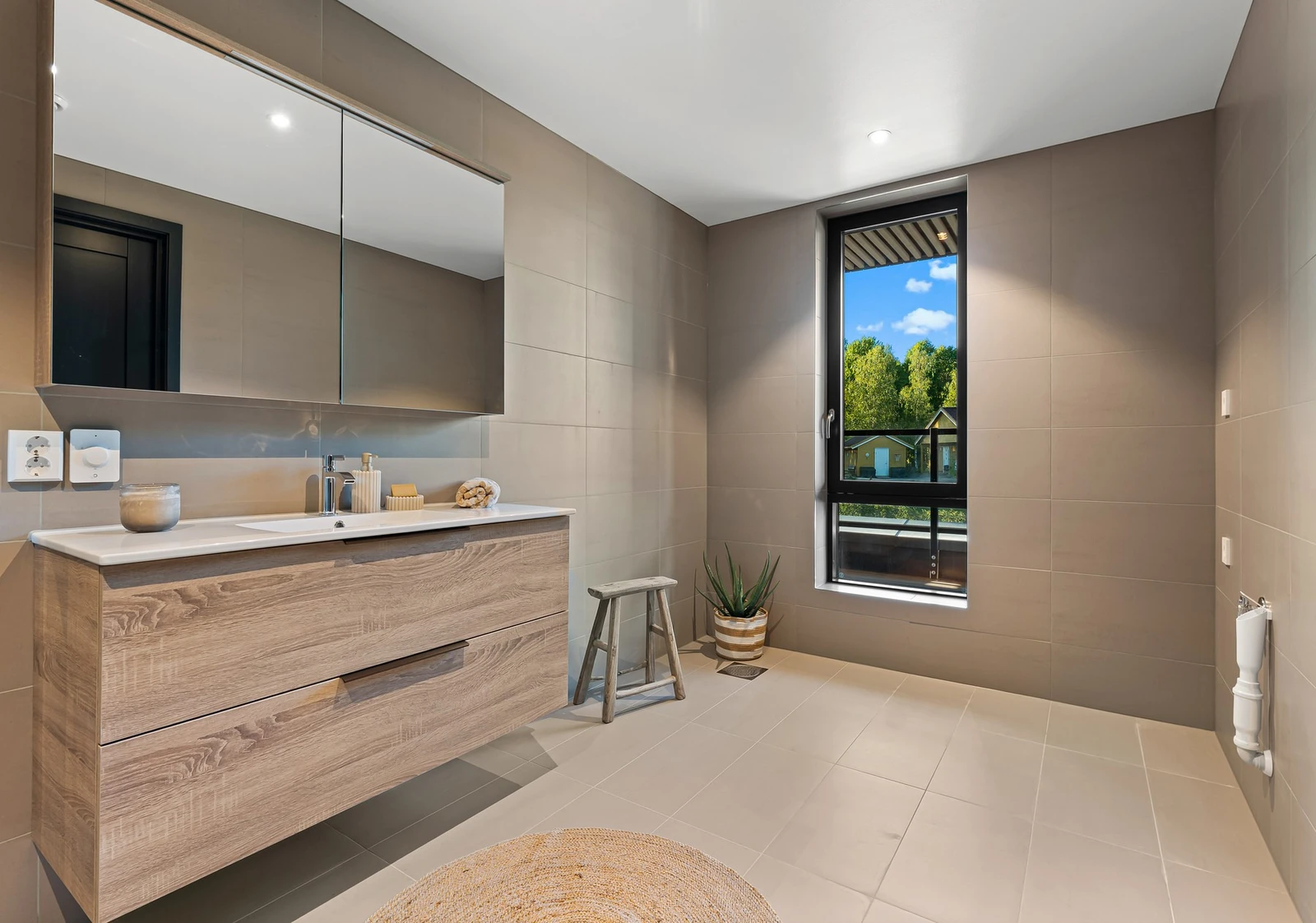 Badet er flislagt i moderne stil med smakfulle material og fargevalg, gulvvarme og downlights, som gir deg en god start på dagen. Galleribilde