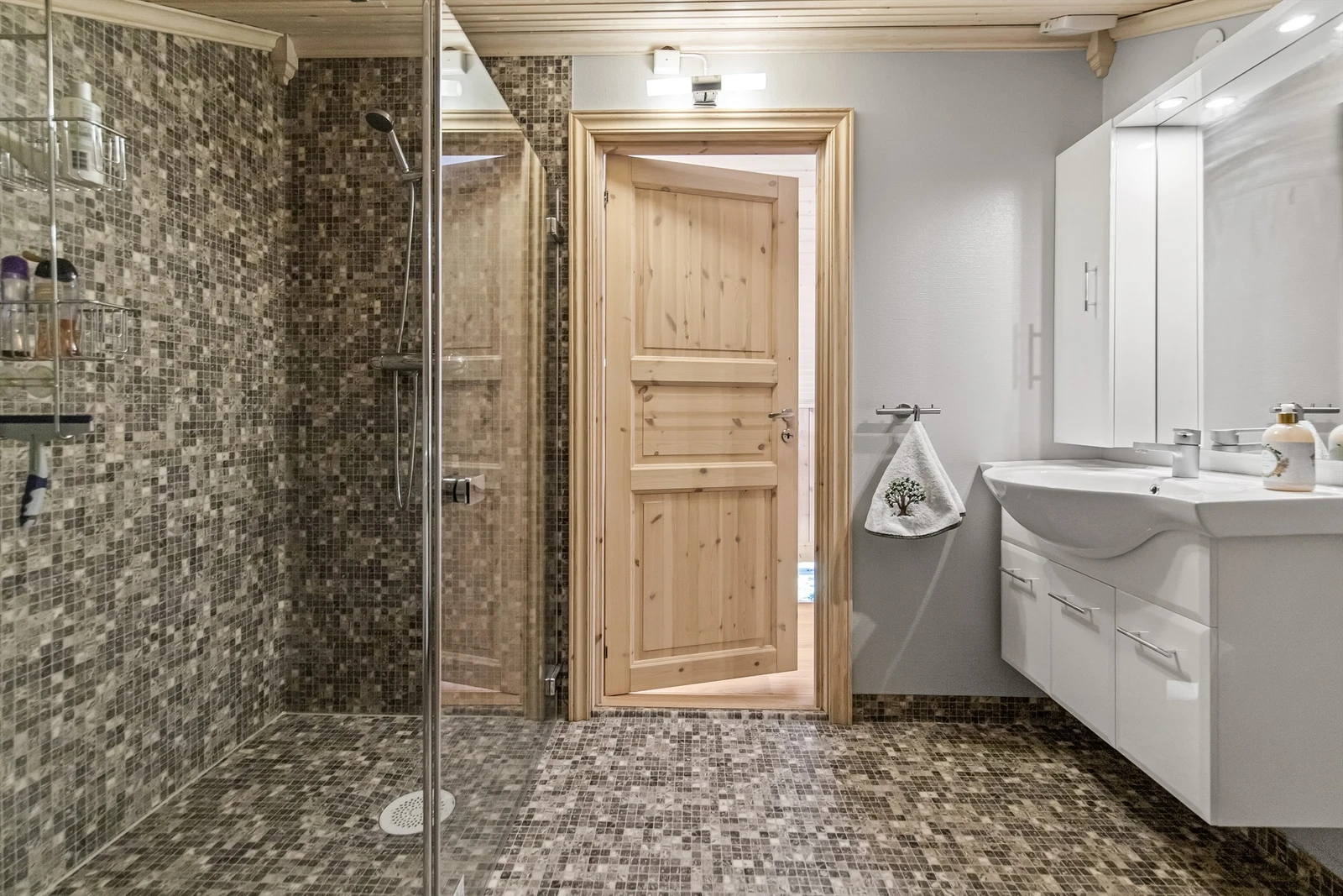 Innredet med varmekabler i gulv, dusjnisje, vegghengt toalett og servant i innredning Galleribilde