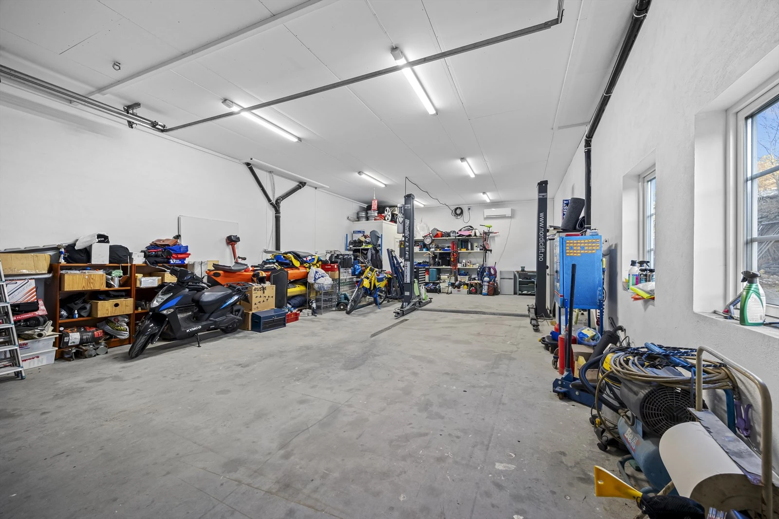 Eiendommen har romslig, isolert garasjeanlegg på grunnplan med god takhøyde (nær 3,4 meter) og bred kjøreport, velegnet til lagring og vedlikehold av kjøretøy. Galleribilde