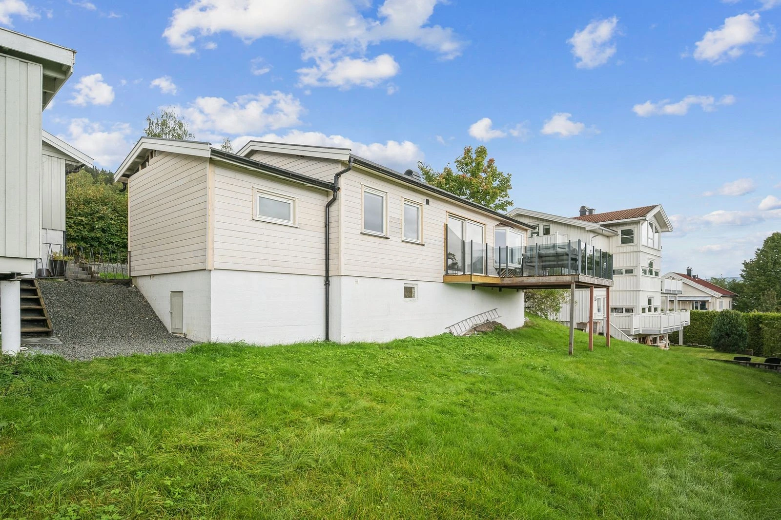 Pent opparbeidet hage med plen og sitteplasser.