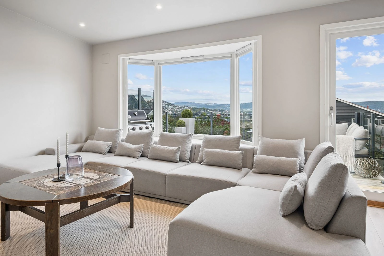 Stue med nydelig utsikt over Drammen by og trivelig plass til sofagruppe.