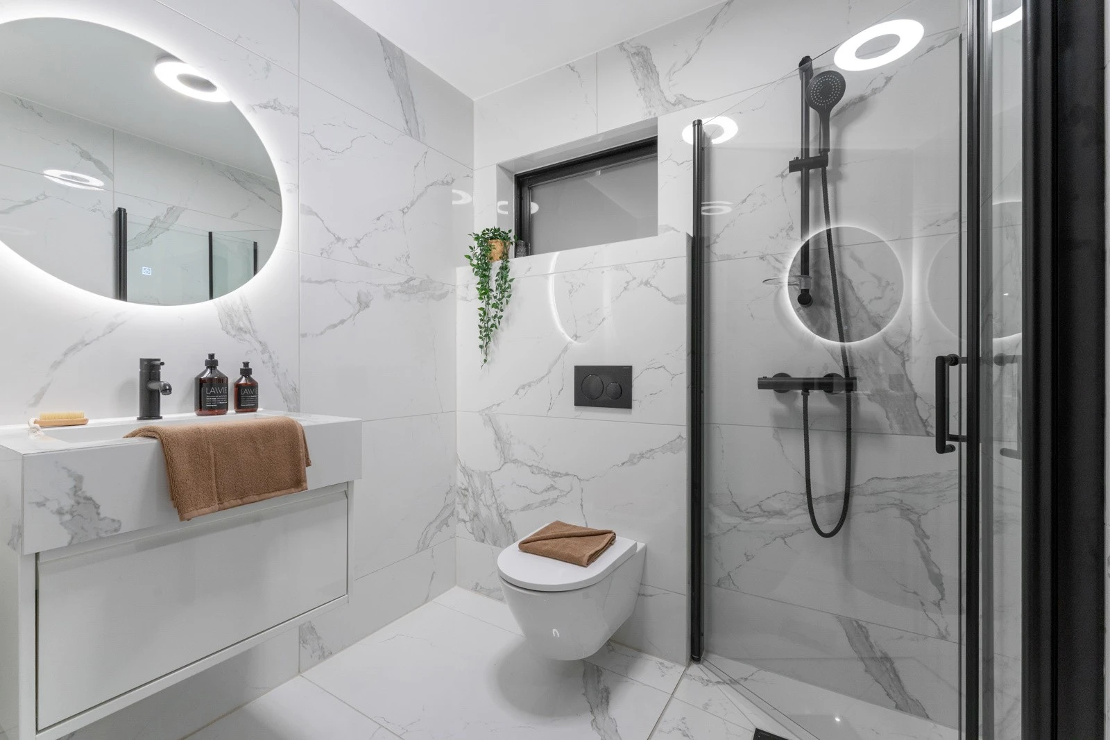 Badet er utstyrt med dusj, veggtoalett og baderomsinnredning m heldekkende servant samt belyst speil. Badet passer perfekt som gjestebad. Galleribilde