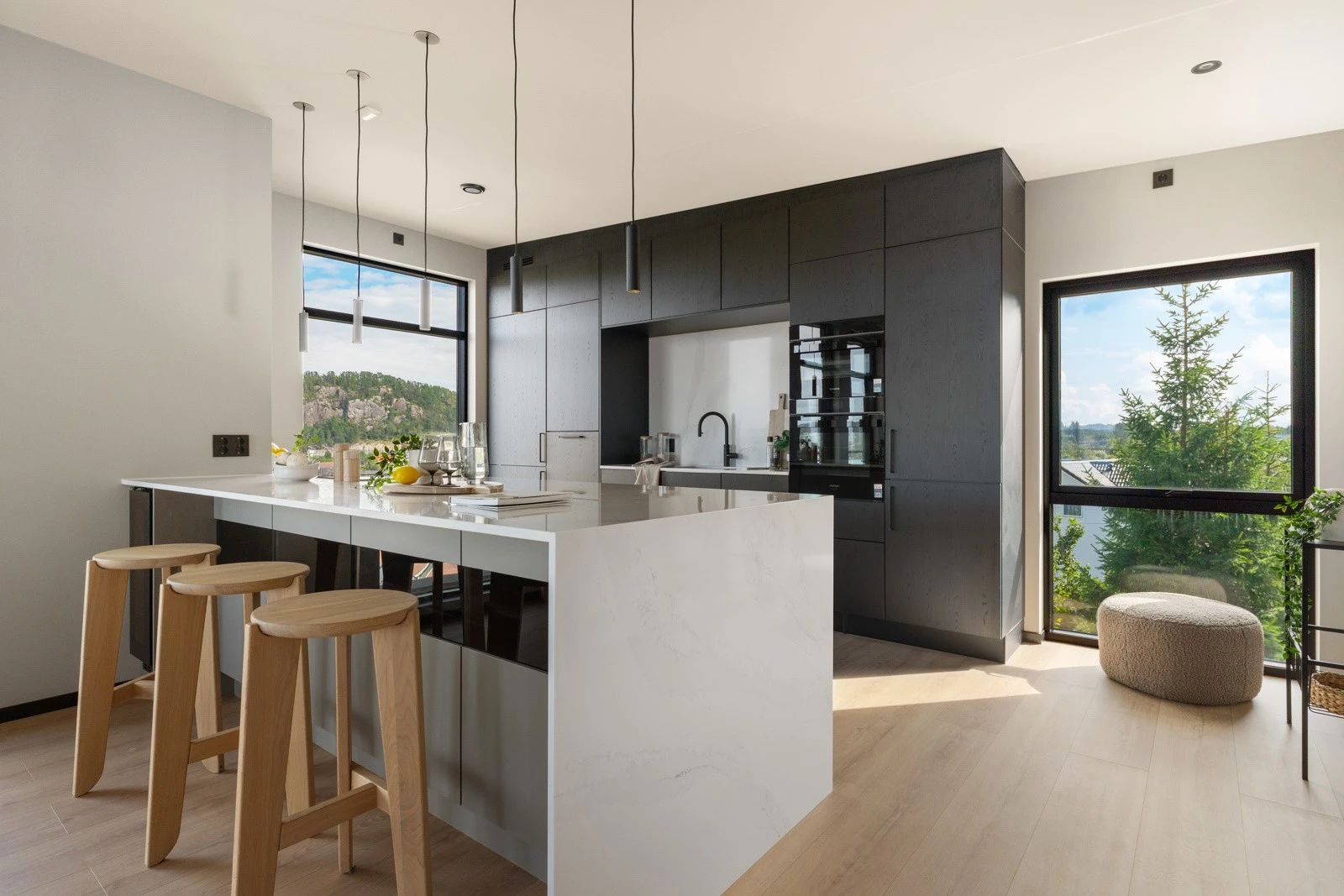 Kjøkkenet er innredet med svarte og hvite, samt glatte fronter og benkeplate i stein med planlimt kjøkkenvask. Galleribilde