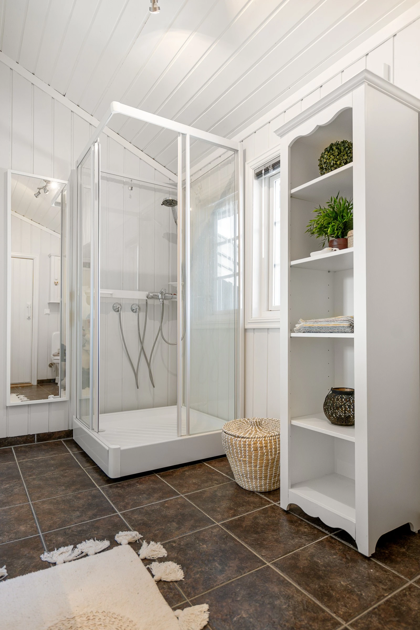 Badet er innredet med servant med skap, dusjkabinett og WC. Galleribilde