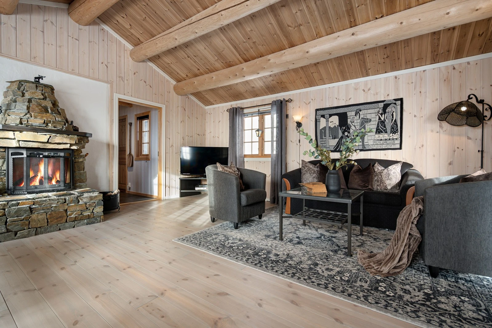 I den ene stuen finner du en koselig peis med innsats, som varmer godt på kjølige høst- og vinterkvelder Galleribilde