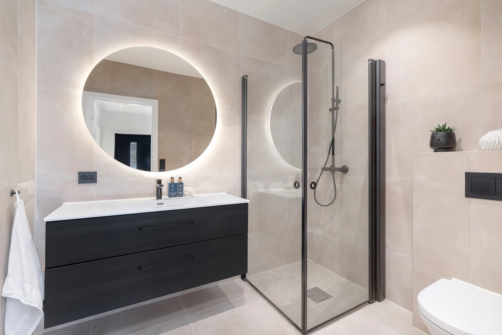 Baderommet er lekkert flislagt med varme i gulv. På badet er det servant med oppbevaring, toalett, og dushjørne Galleribilde