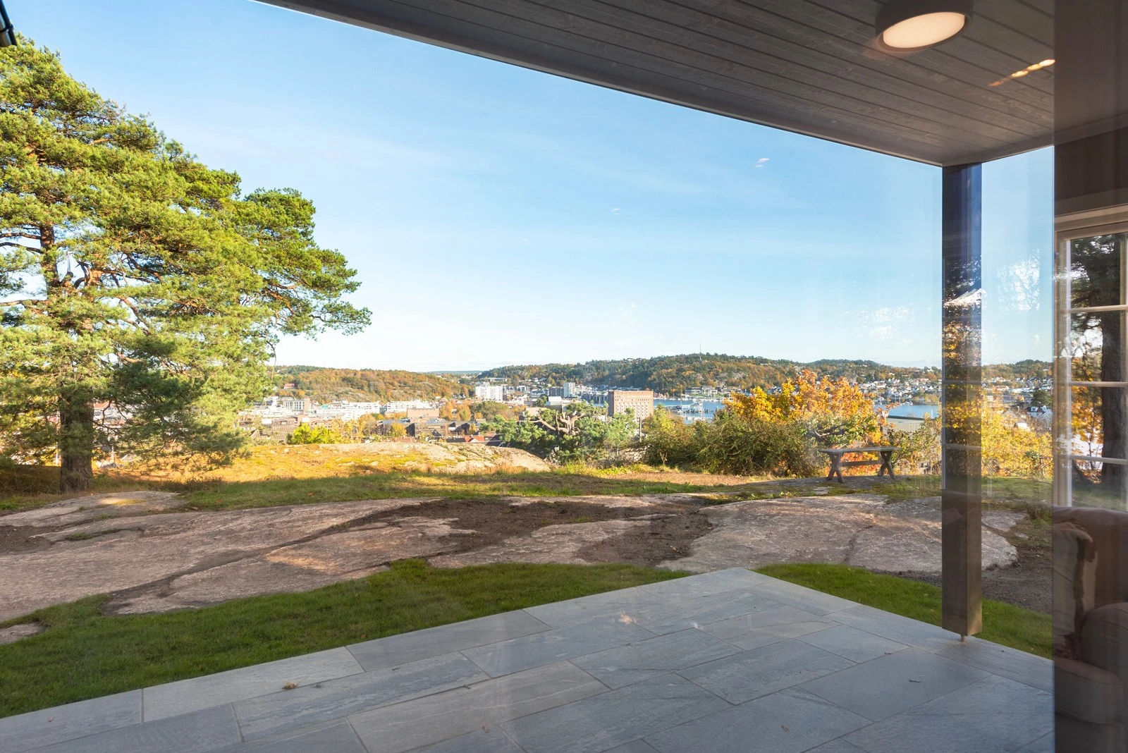 Den delvis overbygde uteplassen med elegant skifterstein gir deg muligheten til å nyte utendørsopplevelser uansett vær. Galleribilde