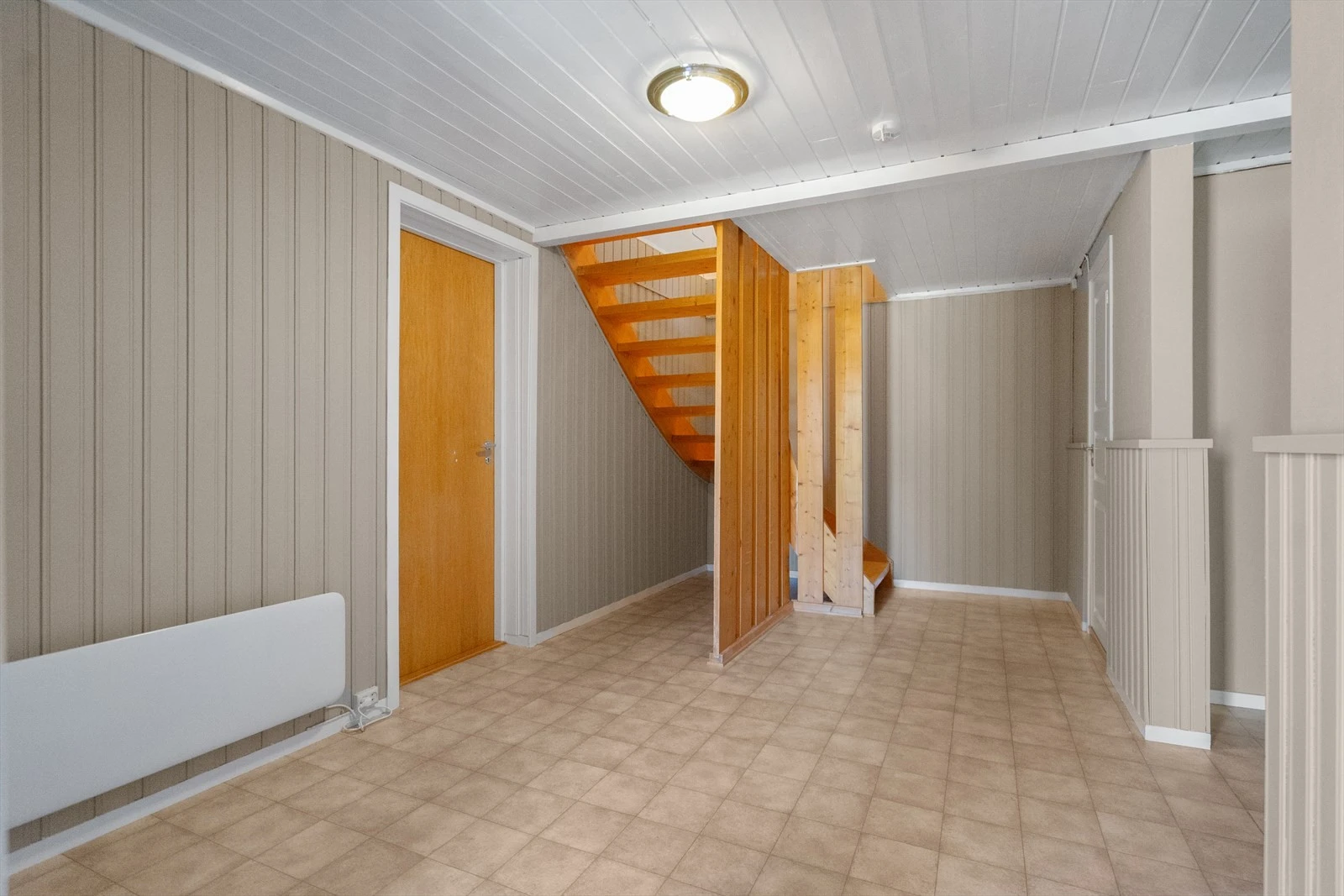 Fra gangen går trappen opp til stue og kjøkken - her ligger det til rette for en praktisk planløsning for både familieliv og gjester Galleribilde