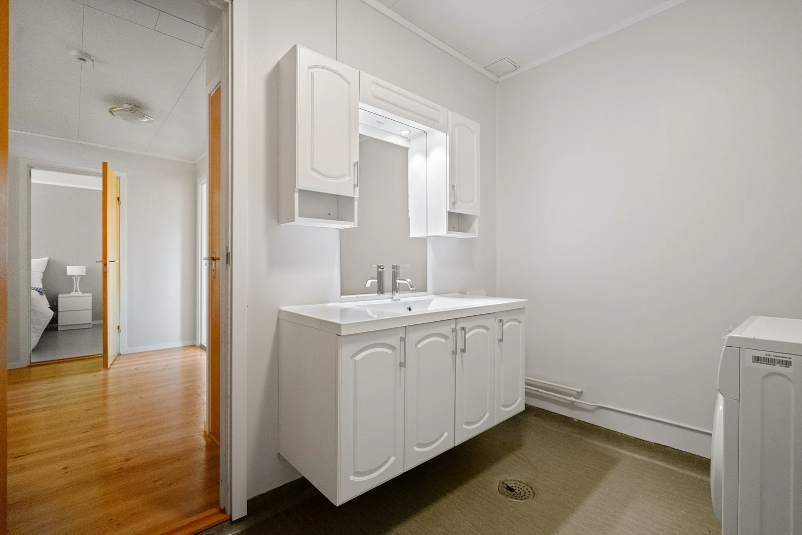 Lyst og praktisk vaskerom med god skapplass og innredning - her er det enkelt å holde orden i hverdagen Galleribilde