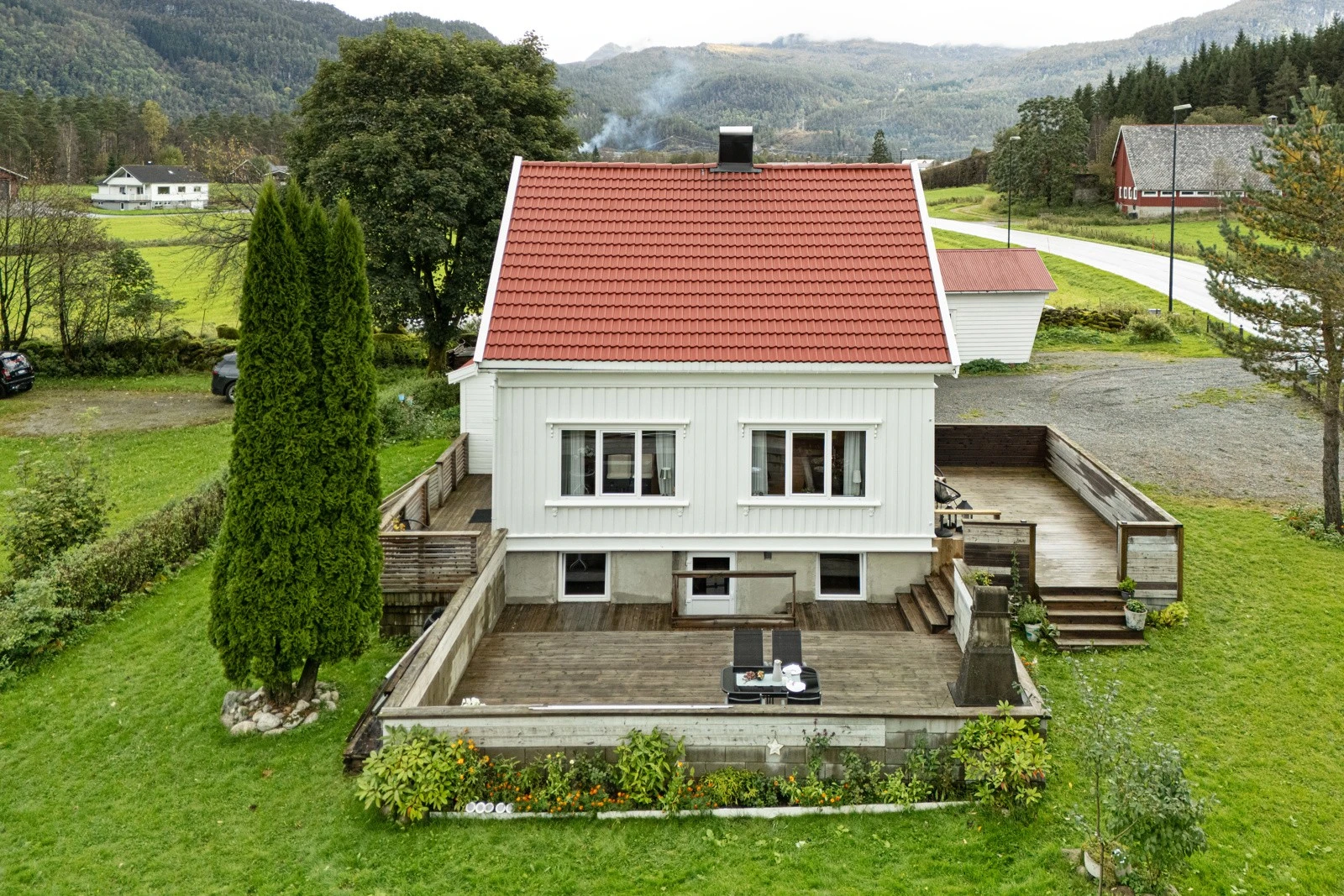 Eiendommen har en romslig tomt som er pent opparbeidet med velholdt hage, prydbusker og trær som gir en innbydende og harmonisk atmosfære. Galleribilde