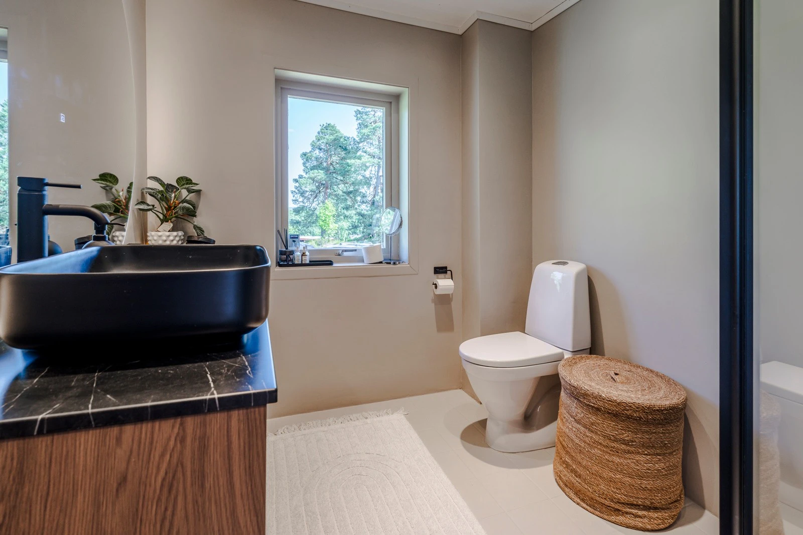 Badet er utstyrt med moderne innredning bestående av slette fronter, heldekkende servant, speil med belysning, dusjkabinett og WC. Galleribilde