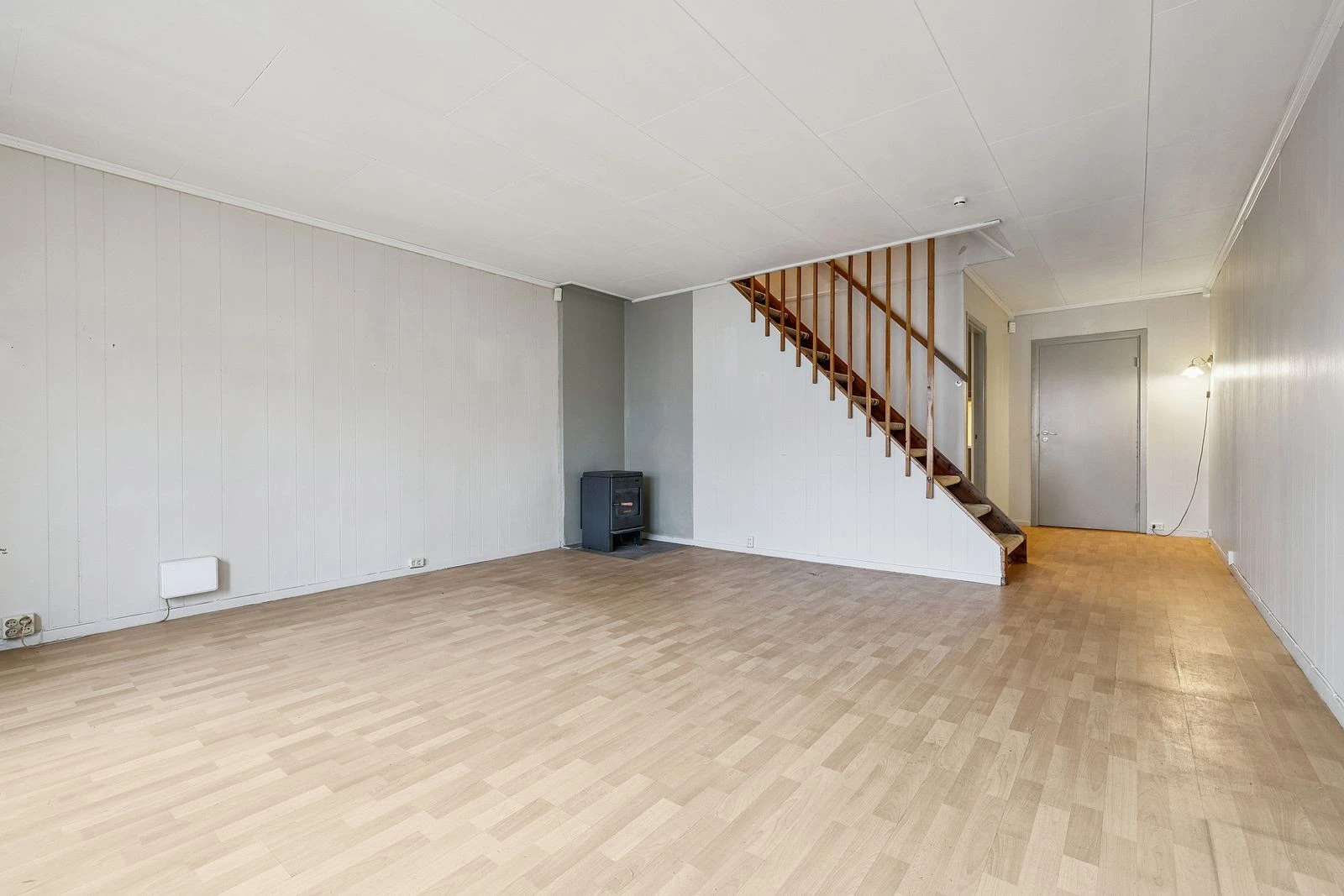 Stuen holder lyse farger, på kalde vinterdager kan boligen oppvarmes med peis.