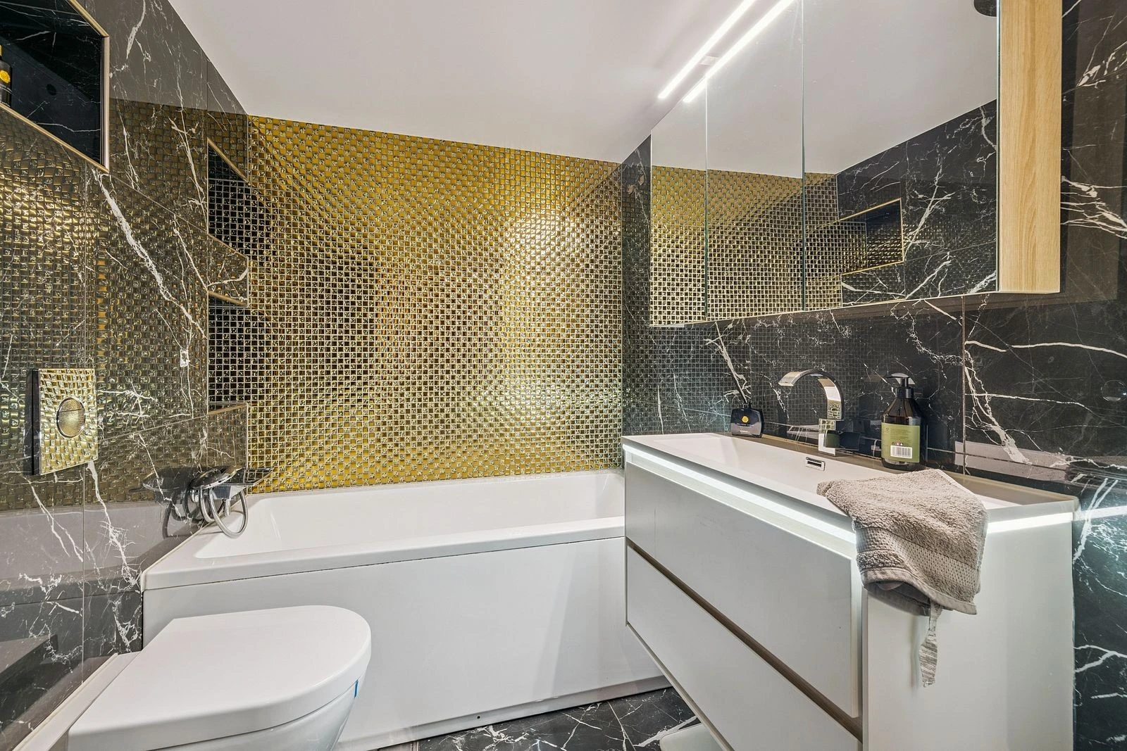 Bad med frittstående badekar og elegant baderomsinnredning.