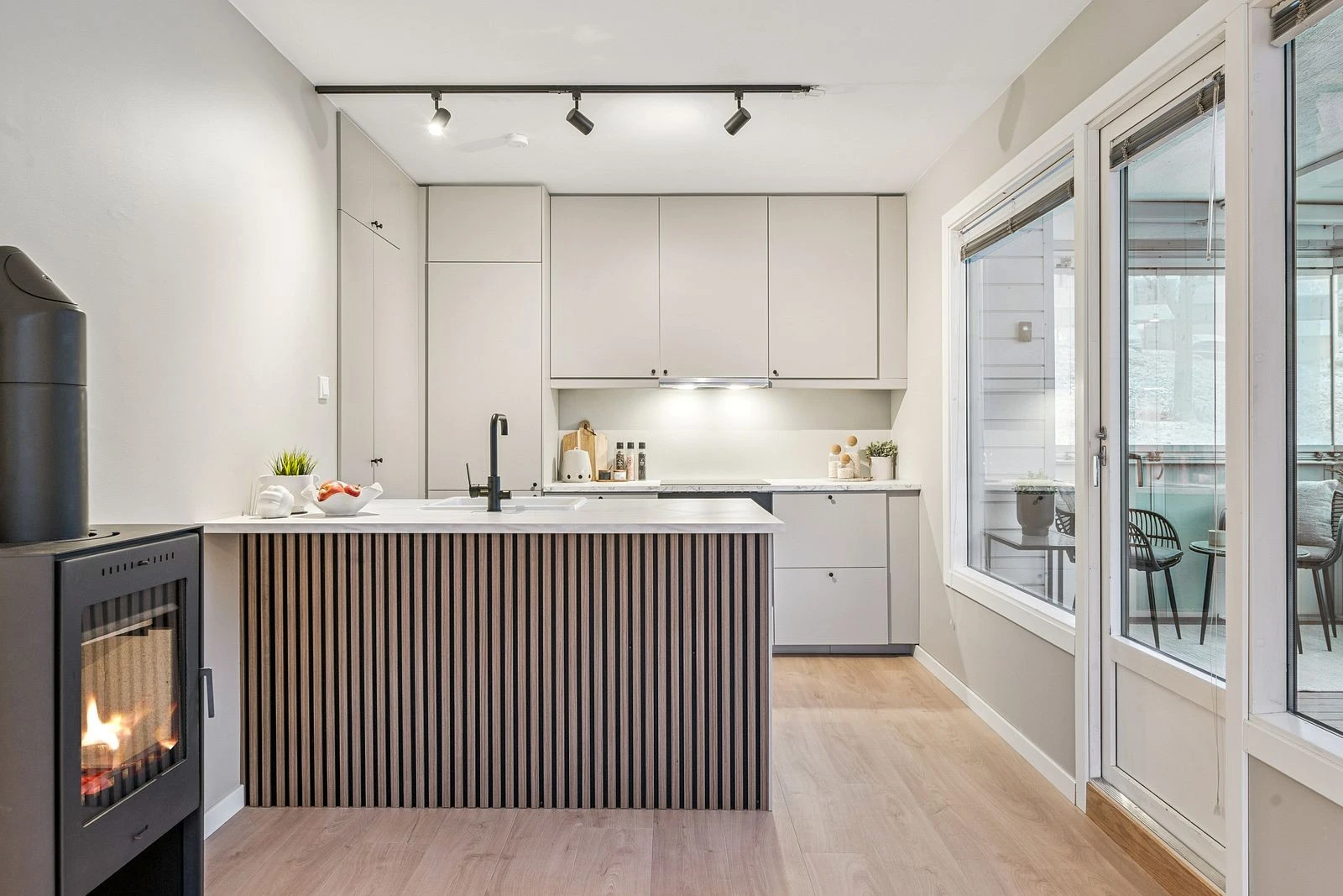 Moderne kjøkken fra 2025 med kjøkkenøy og slette fronter, elegant integrert i stue- og kjøkkenløsning.