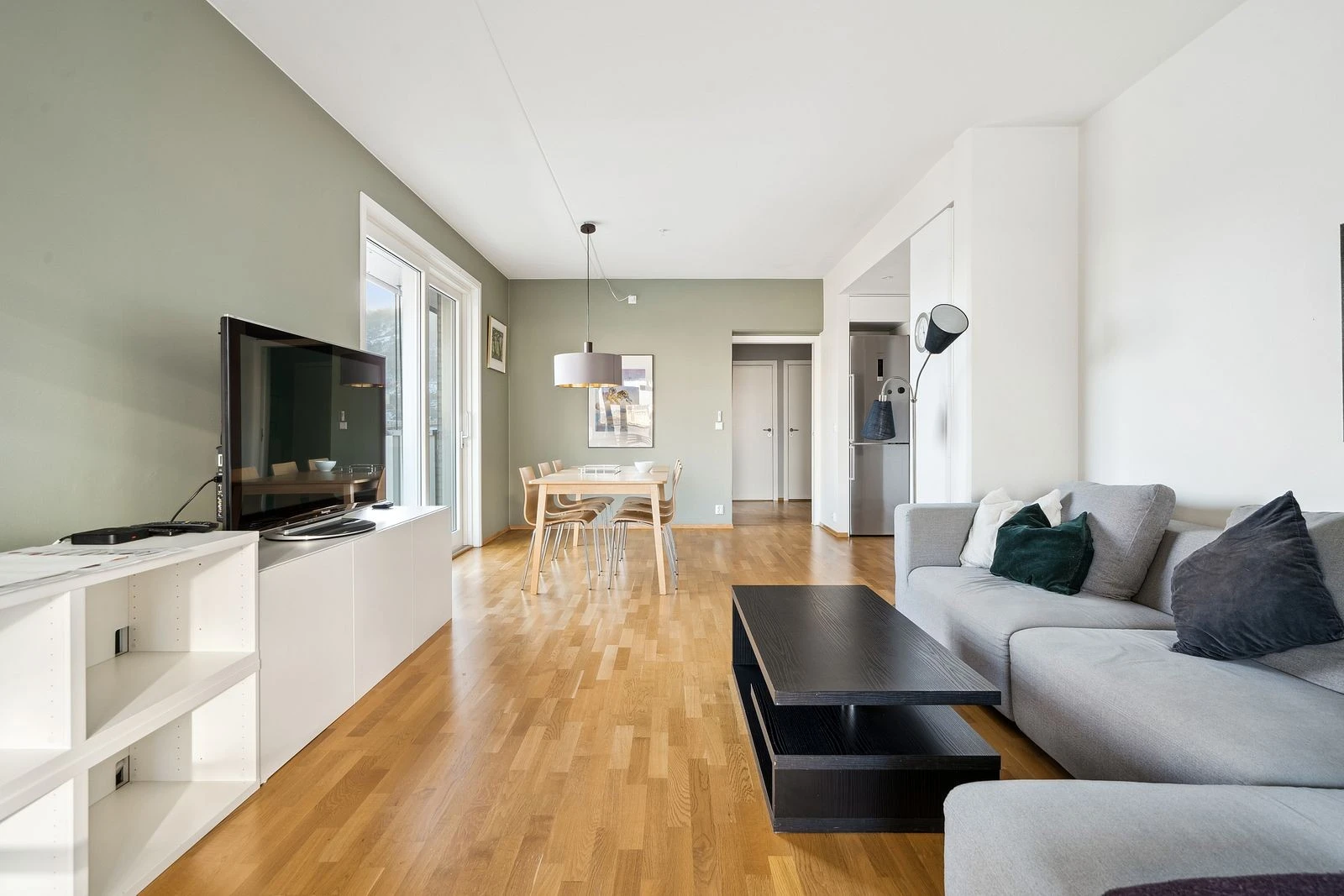 Romslig stue med stor sofa og spisebord Galleribilde