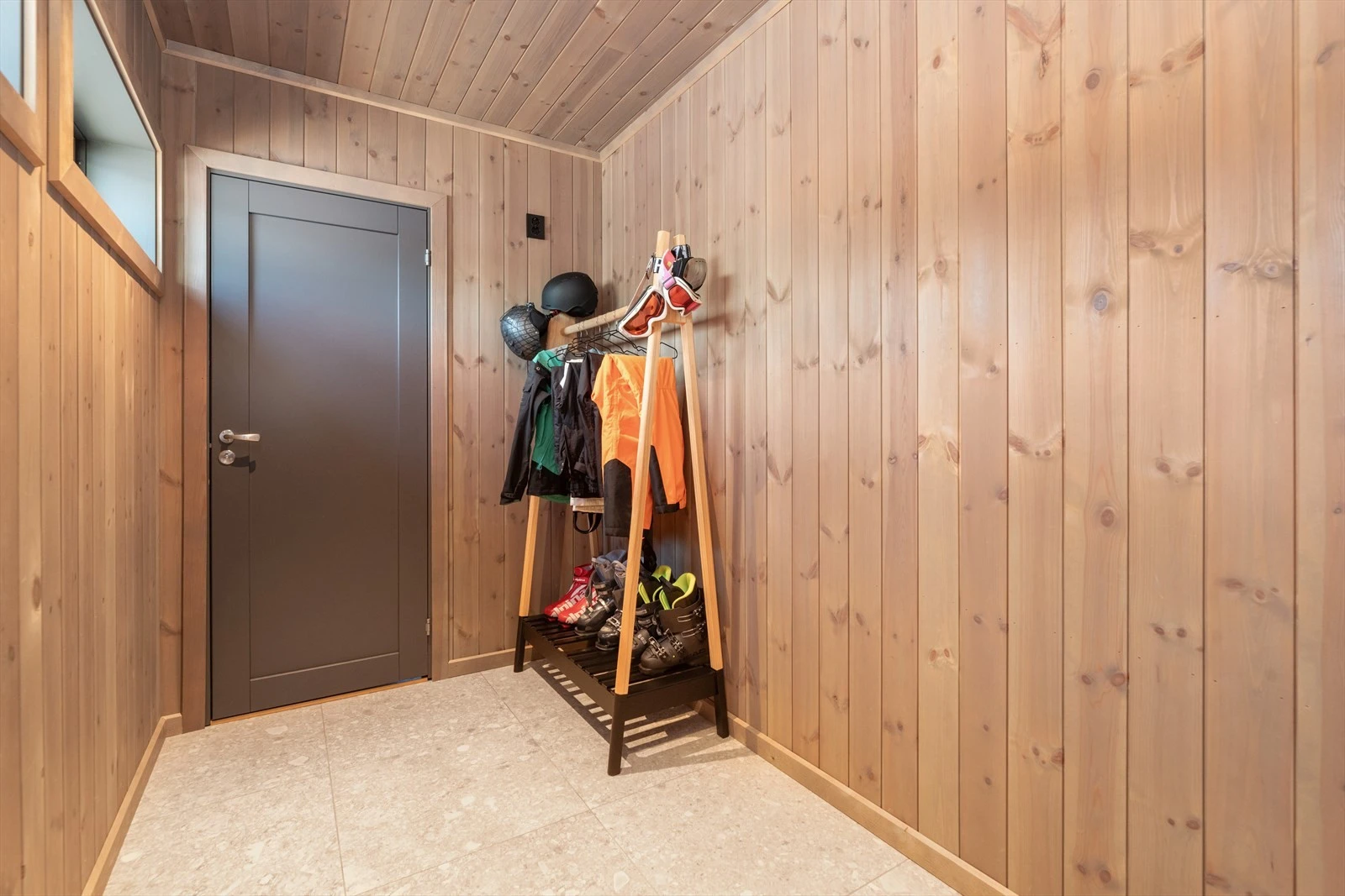 Hytta har en hyggelig entre som ønsker velkommen inn, hvor det er plass til sko og yttertøy. Galleribilde