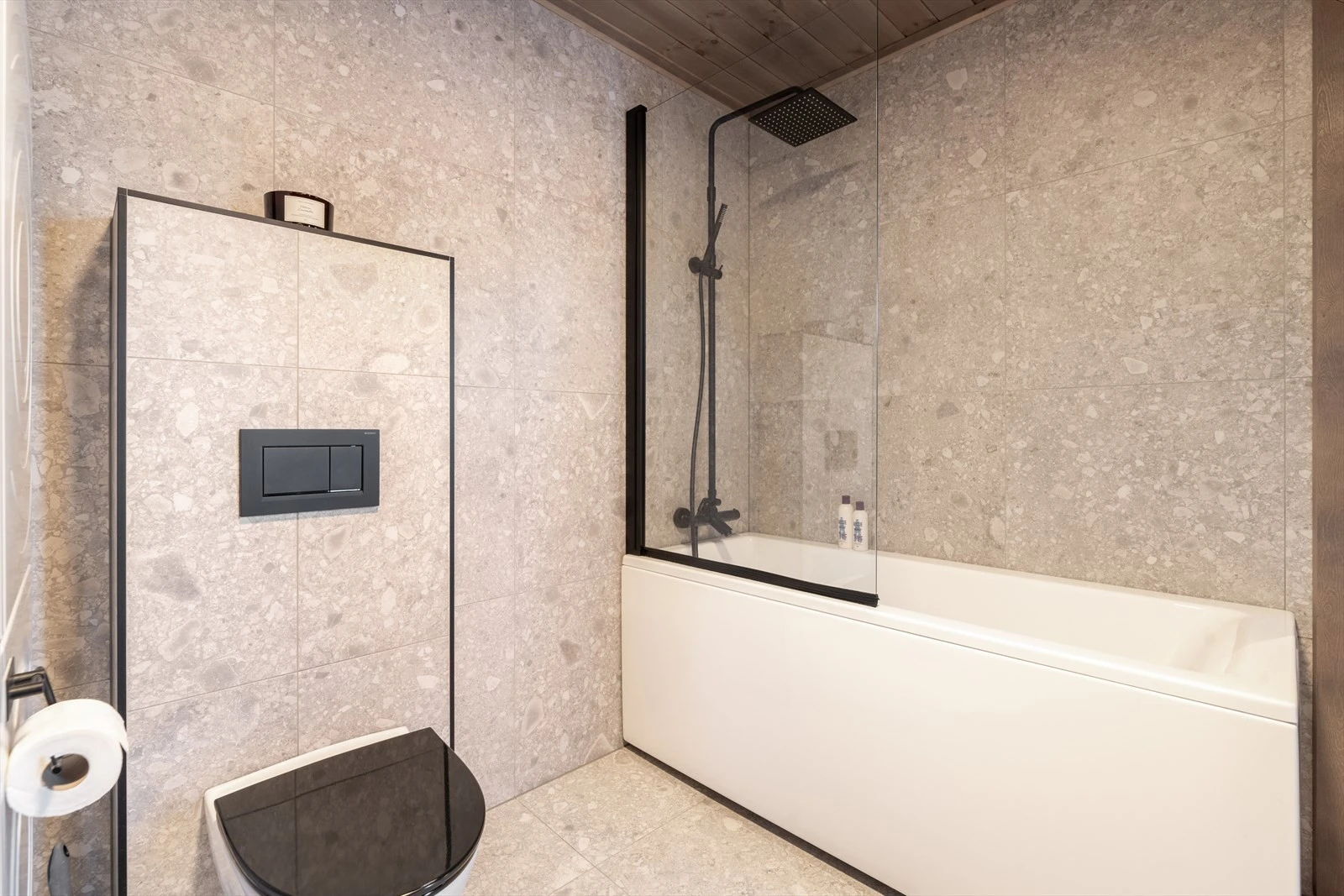 Badet er innredet med vegghengt toalett, badekar med dusj og servantinnredning med underskuffer og speil med lys. Galleribilde