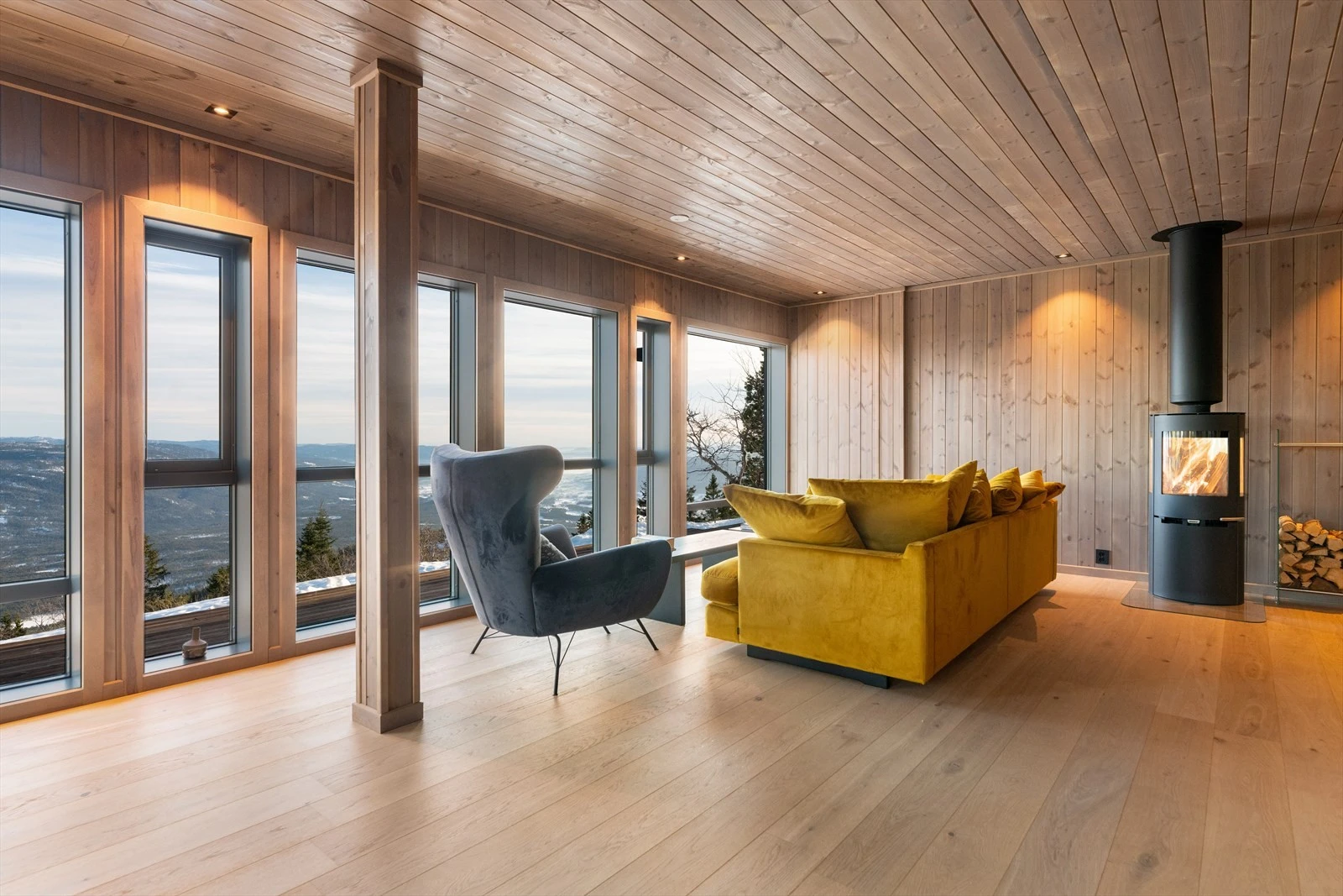 Hytta har en effektiv planløsning som gir fullt utbytte av de 91 kvadratmeterne, samtidig som den gir skjermede oppholdssoner. I stuen er det montert en flott vedovn for lun varme på kaldere dager. Galleribilde