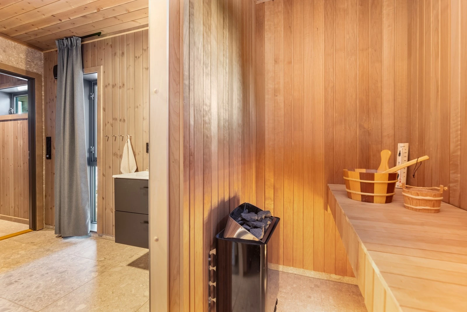 Badet har flis på gulv med gulvvarme, flis og panel på vegger og panel i tak. Galleribilde