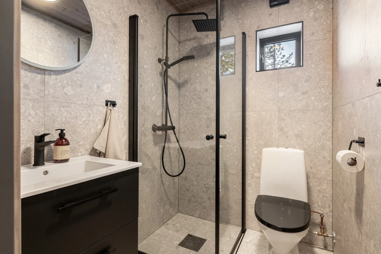 Praktisk, flislagt bad nr 2. Dette badet er innredet med toalett, dusjhjørne og servantinnredning med underskuffer og speil. Galleribilde