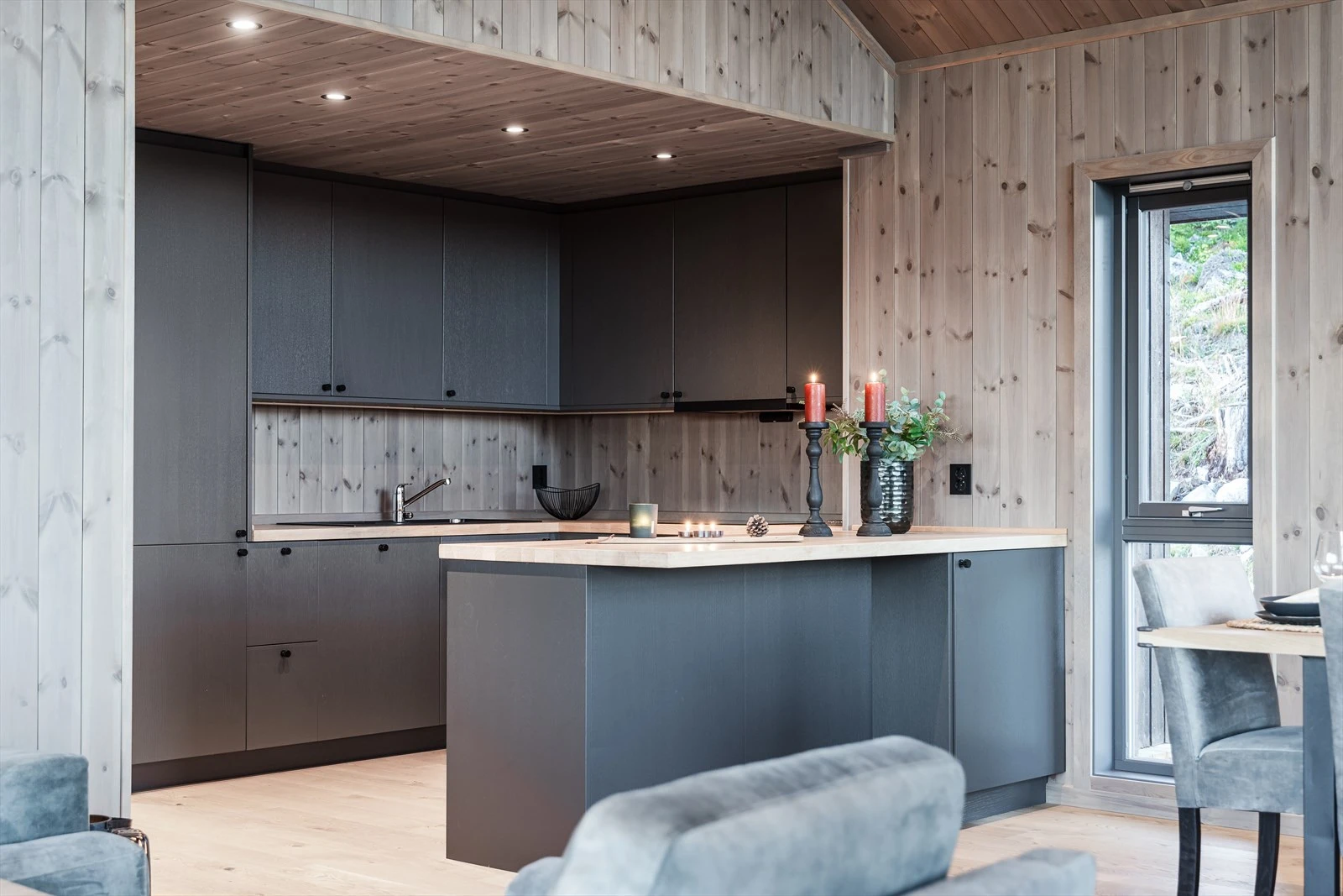 Moderne kjøkken med mørke fronter og varme trepaneler for en stilren og koselig atmosfære Galleribilde