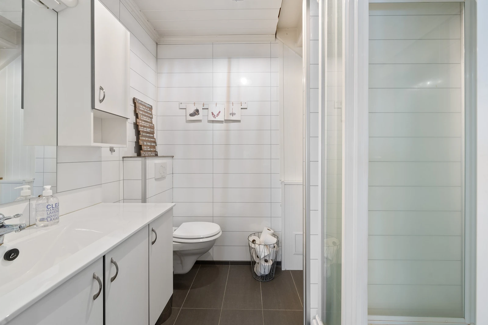 Badet med varmekabler, vegghengt wc, servant med skap under og overskap. Dusjhjørne. Galleribilde