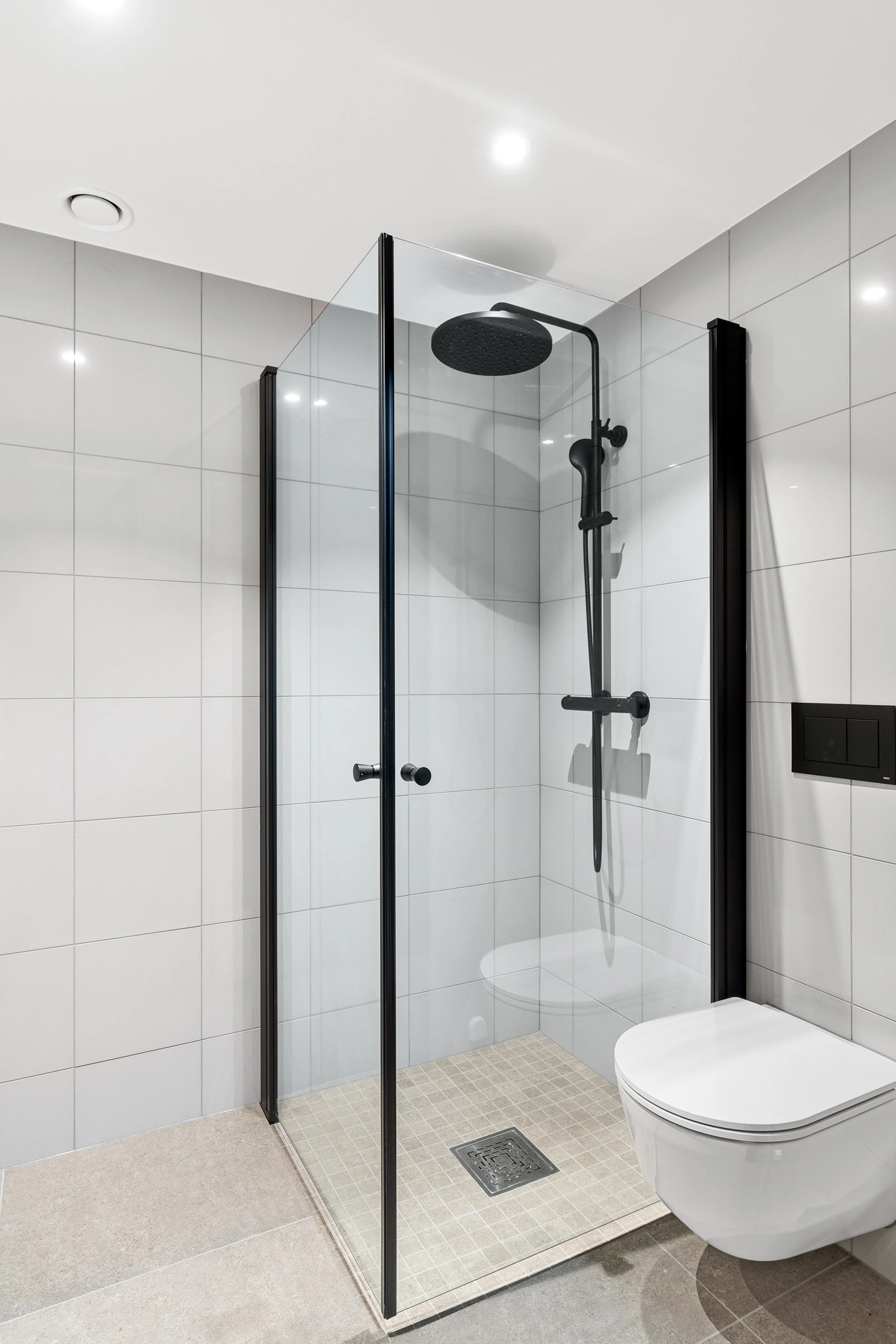 Vegghengt toalett og tidsriktig dusjhjørne hvor dørene kan slås helt inn. Galleribilde