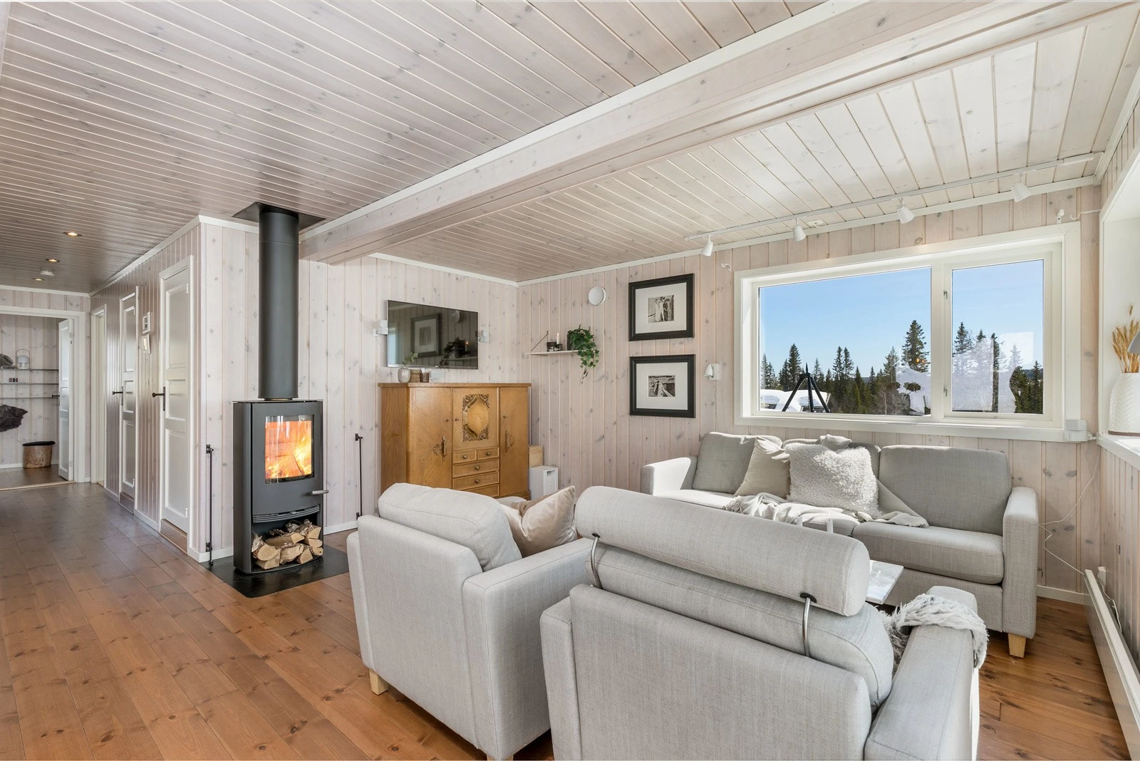 Midt i rommet er det en flott peisovn som gir god varme og hygge. Galleribilde