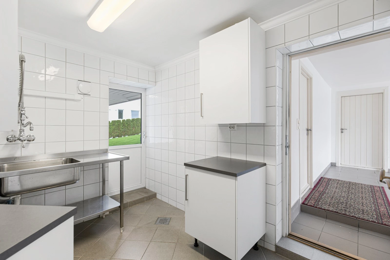 Flislagt vaskerom med tilkomst til dobbelgarasje. Galleribilde