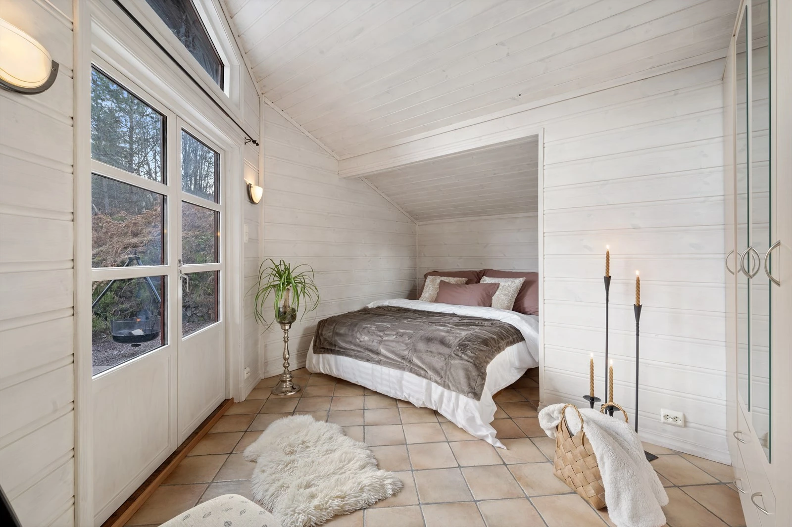 Romslig hovedsoverom med adgang ut på stor markterrasse via doble balkongdører. Galleribilde