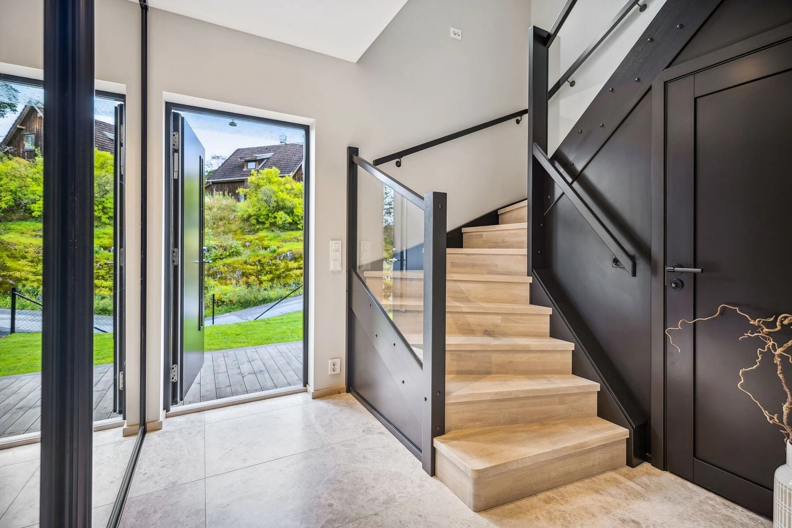 Entreen er flislagt med varme i gulv og tilbyr rikelig med oppbevaring i både skyvedørsgarderobe med speilfronter og eget trapperom til oppbevaring.. Galleribilde