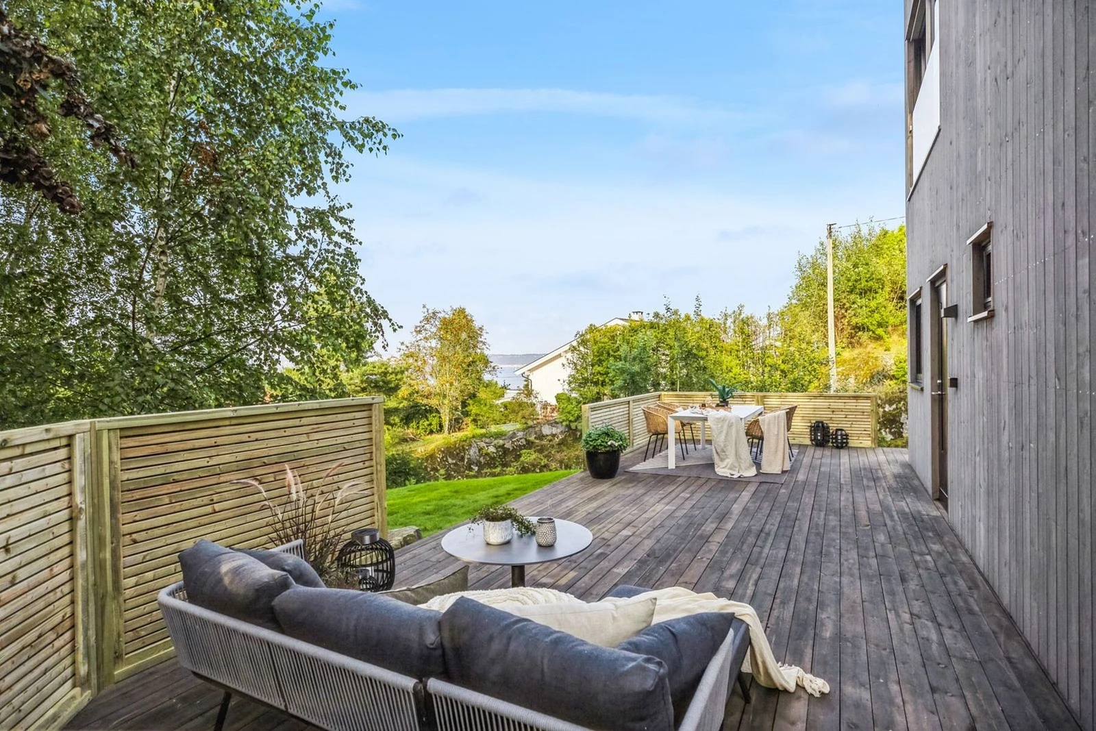 Stor nordvest- og nordøstvendt terrasse i trekonstruksjon i forbindelse med inngangsparti og med adkomst fra ett soverom i 1. etasje, ca. 60 m². Galleribilde